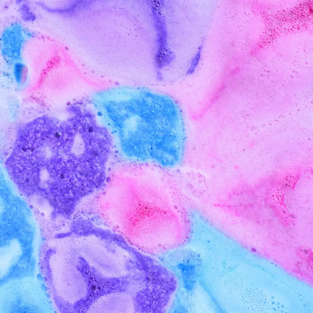 Vibrantly colored bath water created by Black Raspberry Vanilla Bath Bomb Crumble, showcasing pink, blue, and purple swirls.