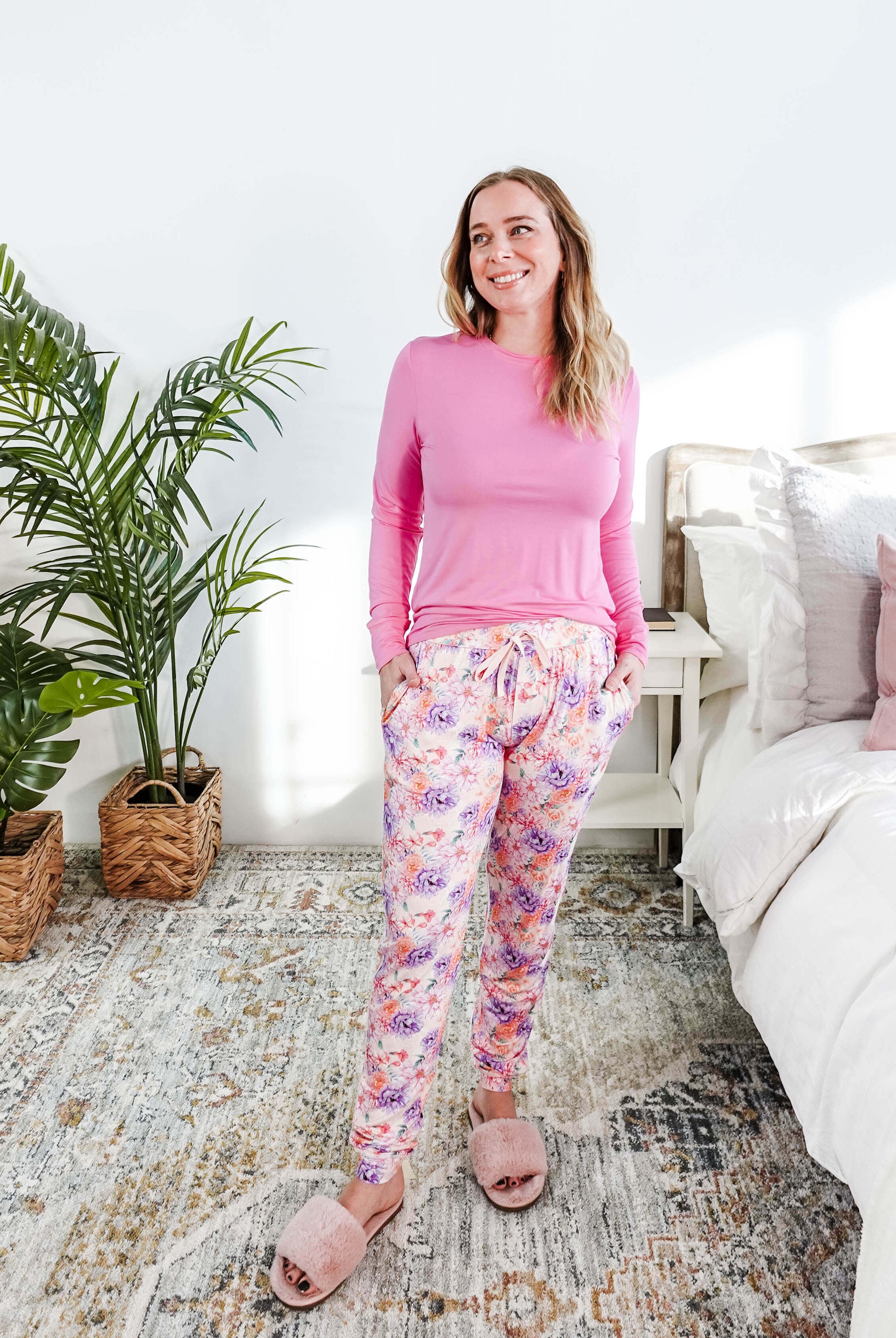 Model wearing the Dream In Blooms Long Sleeve Top & Jogger Bamboo Lounge Set in a cozy bedroom with greenery.