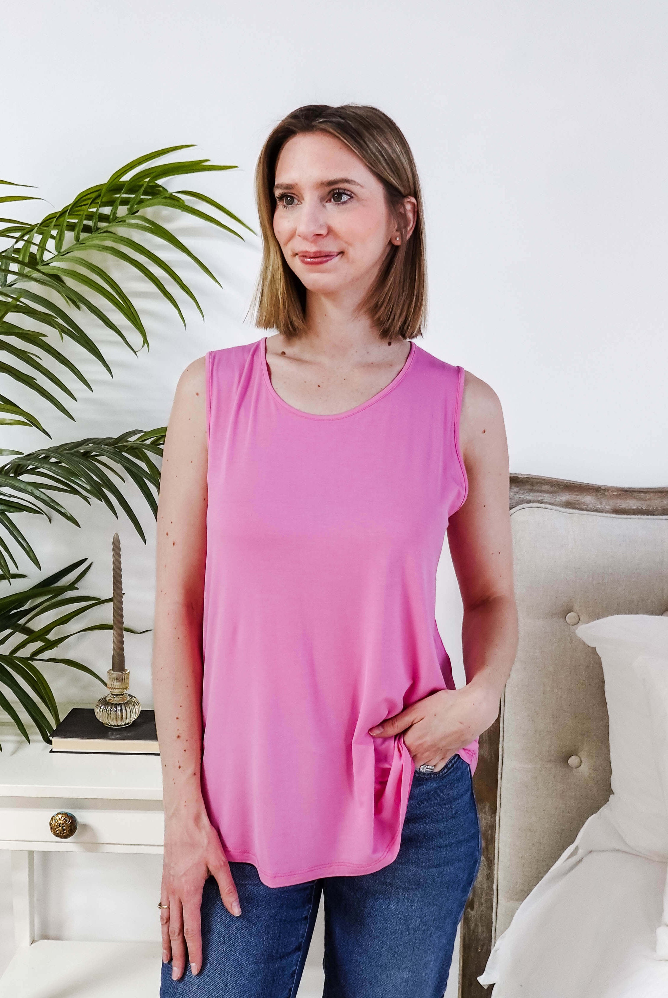 Woman wearing Bubblegum Pink Essential Bamboo Tank Top, showcasing comfort and style in a bright pink color.
