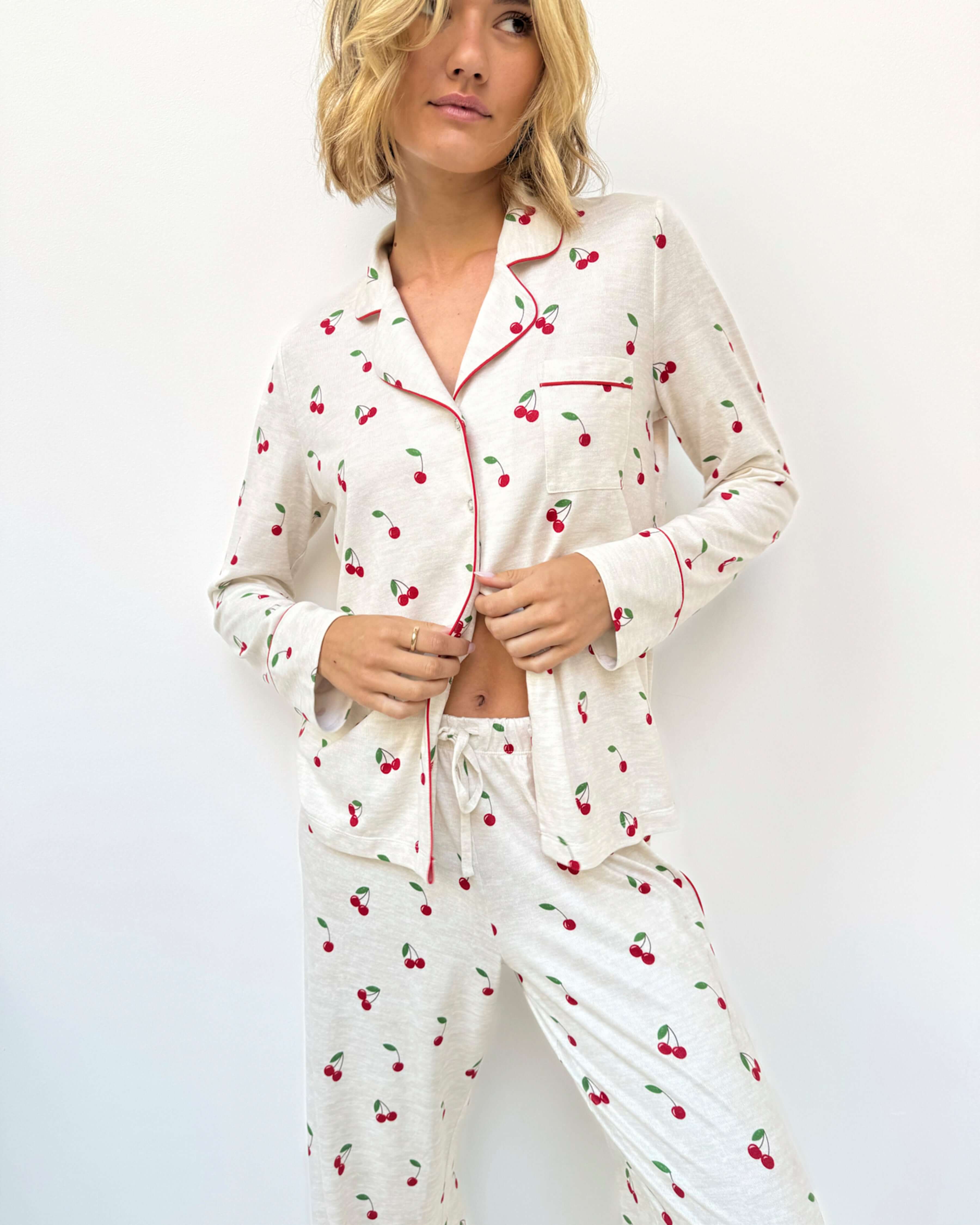 Model wearing the Flora Pillowsoft Sleep Set Splendid, featuring silky soft button-down pajamas with a cherry design.