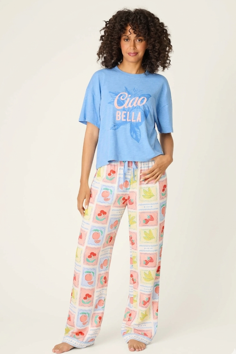 Frutta Fresca Ciao Bella Fruit Print PJ Set by PJ Salvage model wearing a blue top and colorful fruit print pants.