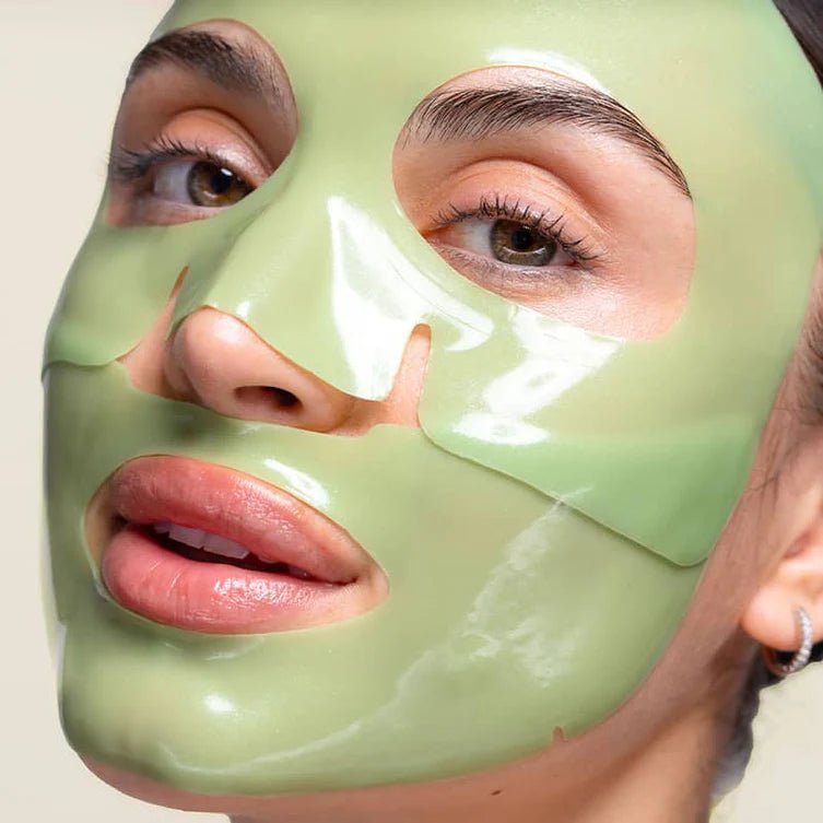 Person wearing a green face mask with a neutral background, Patchology Cool Crush cryo-inspired hydrogel face mask depuffing