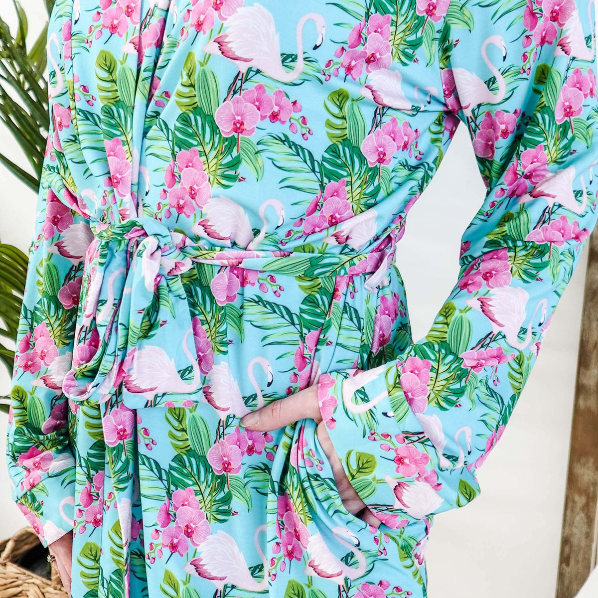 Cooling Bamboo Short Robe with Pockets Tropic Like It's Hot Bamboo Short Robe | Georgia Rylanclose up of print of pink flamingos and orchids on a sky blue background and green tropical leaves