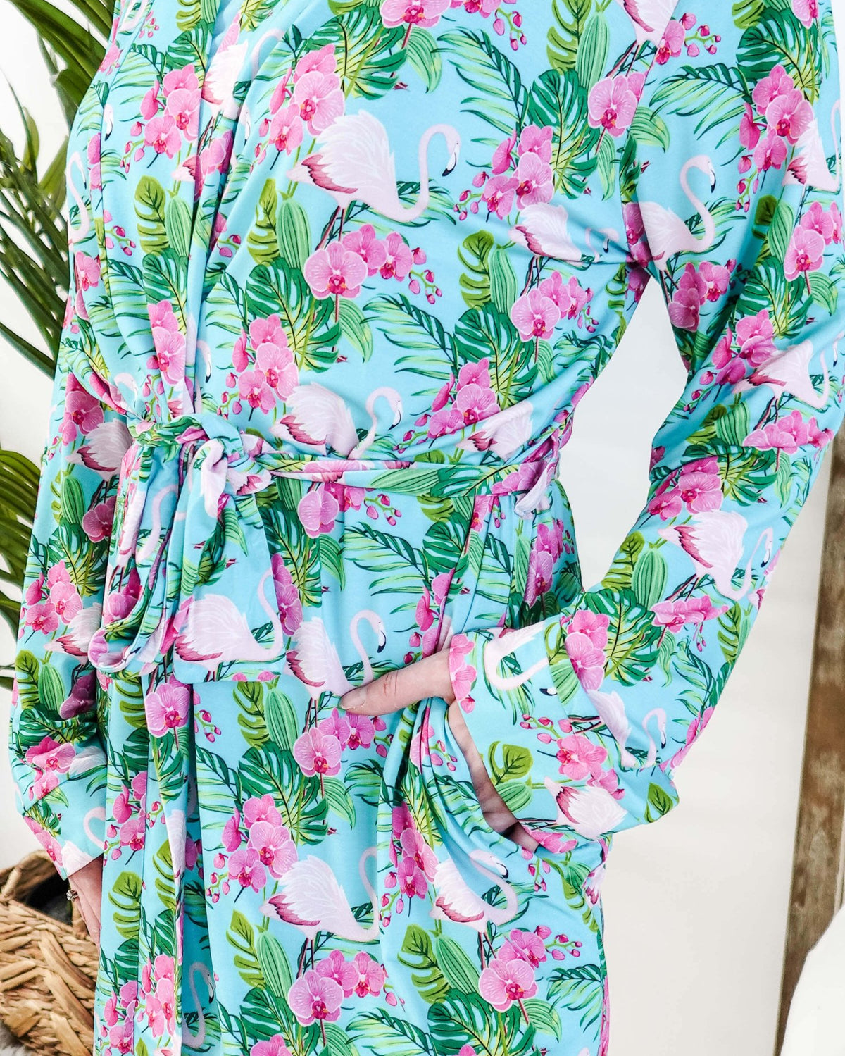 Cooling Bamboo Short Robe with Pockets Tropic Like It's Hot Bamboo Short Robe | Georgia Rylanclose up of print of pink flamingos and orchids on a sky blue background and green tropical leaves