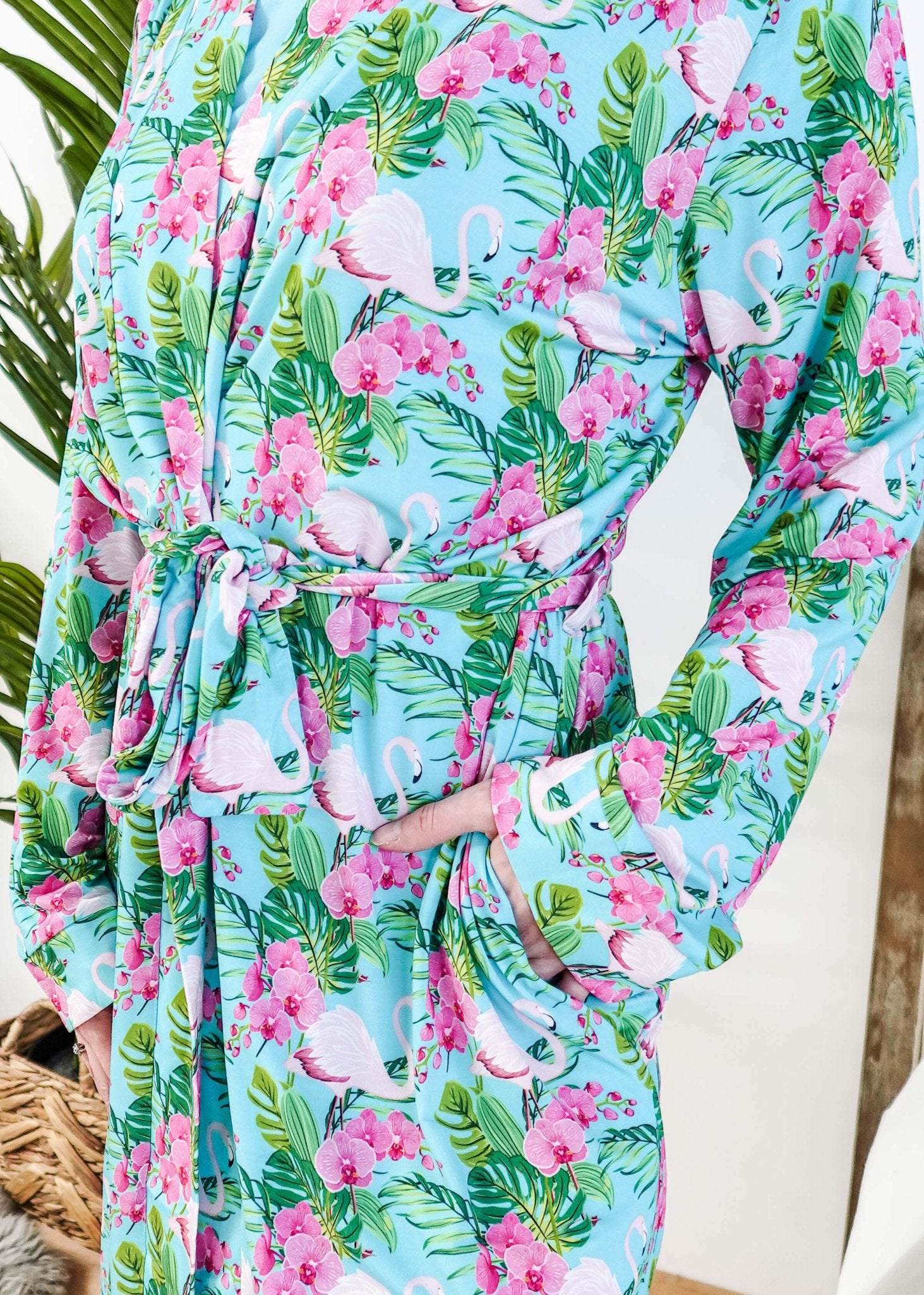 Cooling Bamboo Short Robe with Pockets Tropic Like It's Hot Bamboo Short Robe | Georgia Rylanclose up of print of pink flamingos and orchids on a sky blue background and green tropical leaves