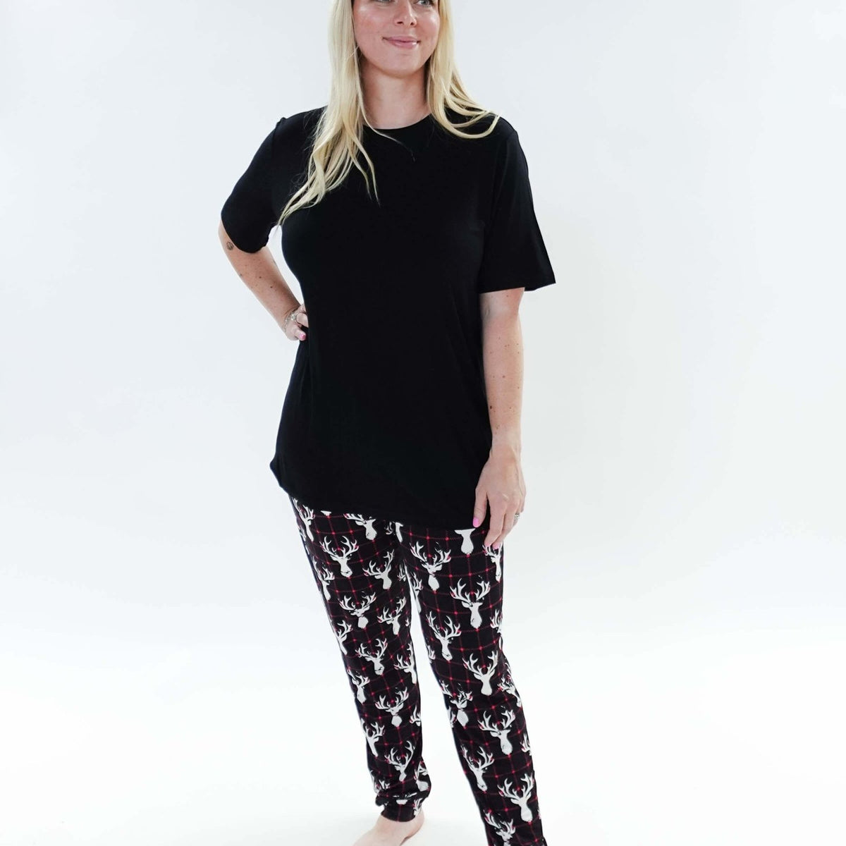 Woman wearing Deer Plaid Unisex Bamboo Jogger and a black top, showcasing comfort and style in sleepwear.