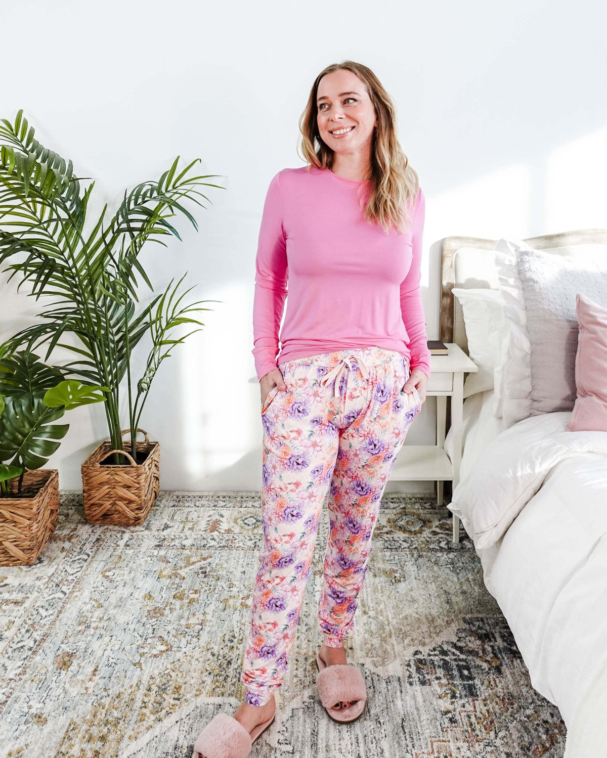 Model wearing the Dream In Blooms Long Sleeve Top & Jogger Bamboo Lounge Set in a cozy bedroom with greenery.