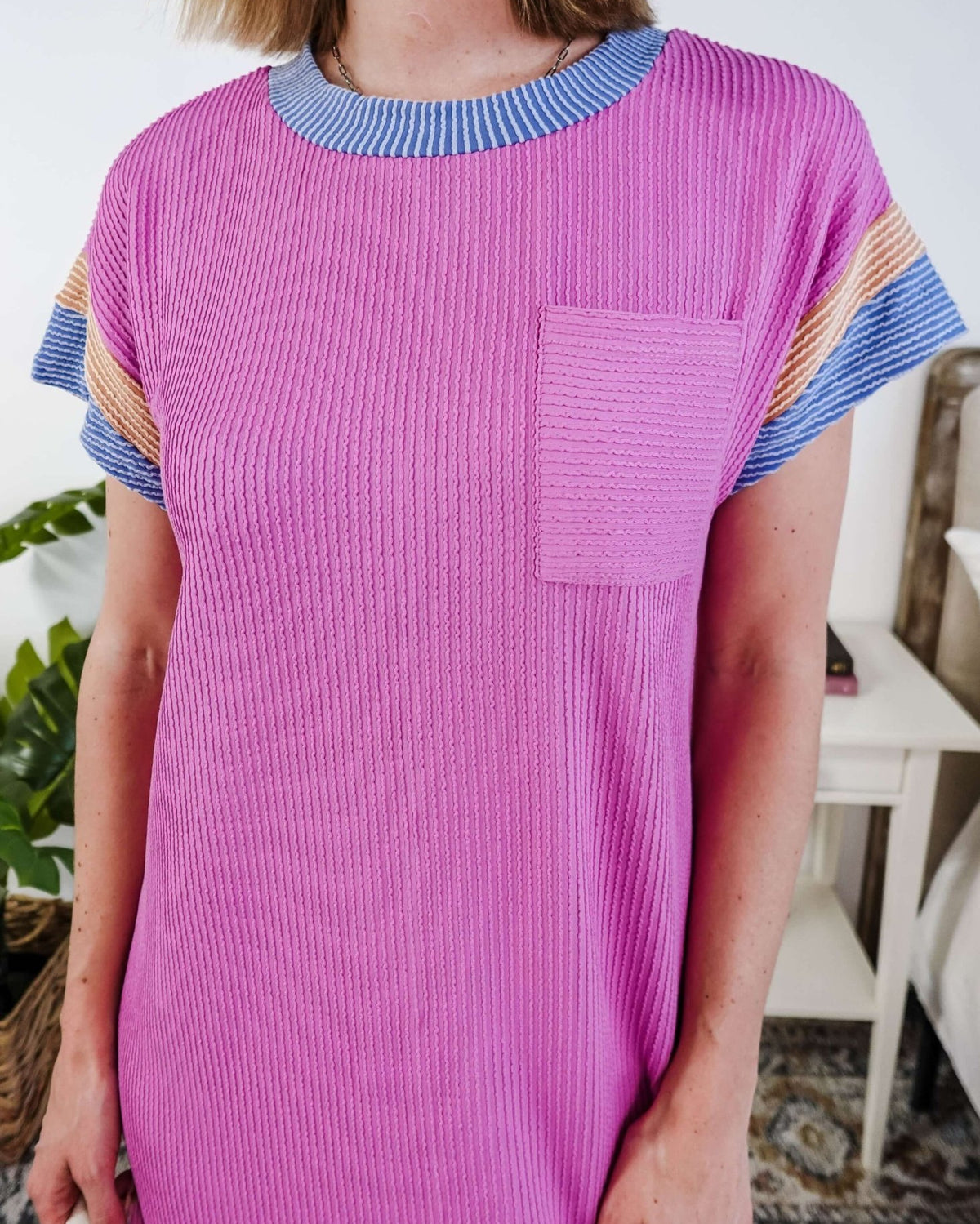 Woman wearing a pink dress with purple and peach sleeve dress in a bedroom setting, Scarlett Ellie Everyday Relaxed T-Shirt Dress | Cloud Nine Pajamas