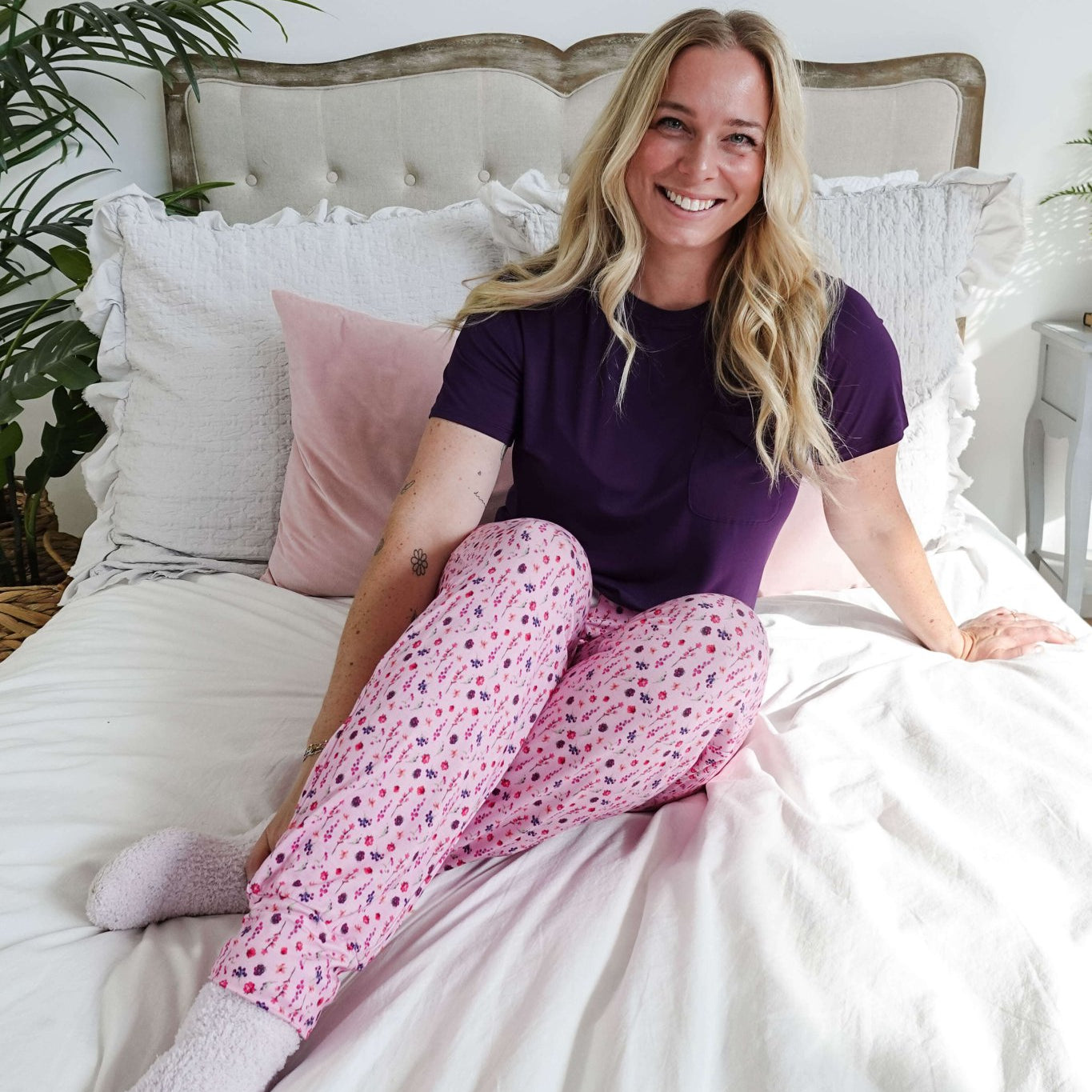 Woman in a purple tee and pink floral jogger pants, showcasing Flora's Garden Print Tee Floral Jogger PJ Set Bamboo from Georgia Rylan.