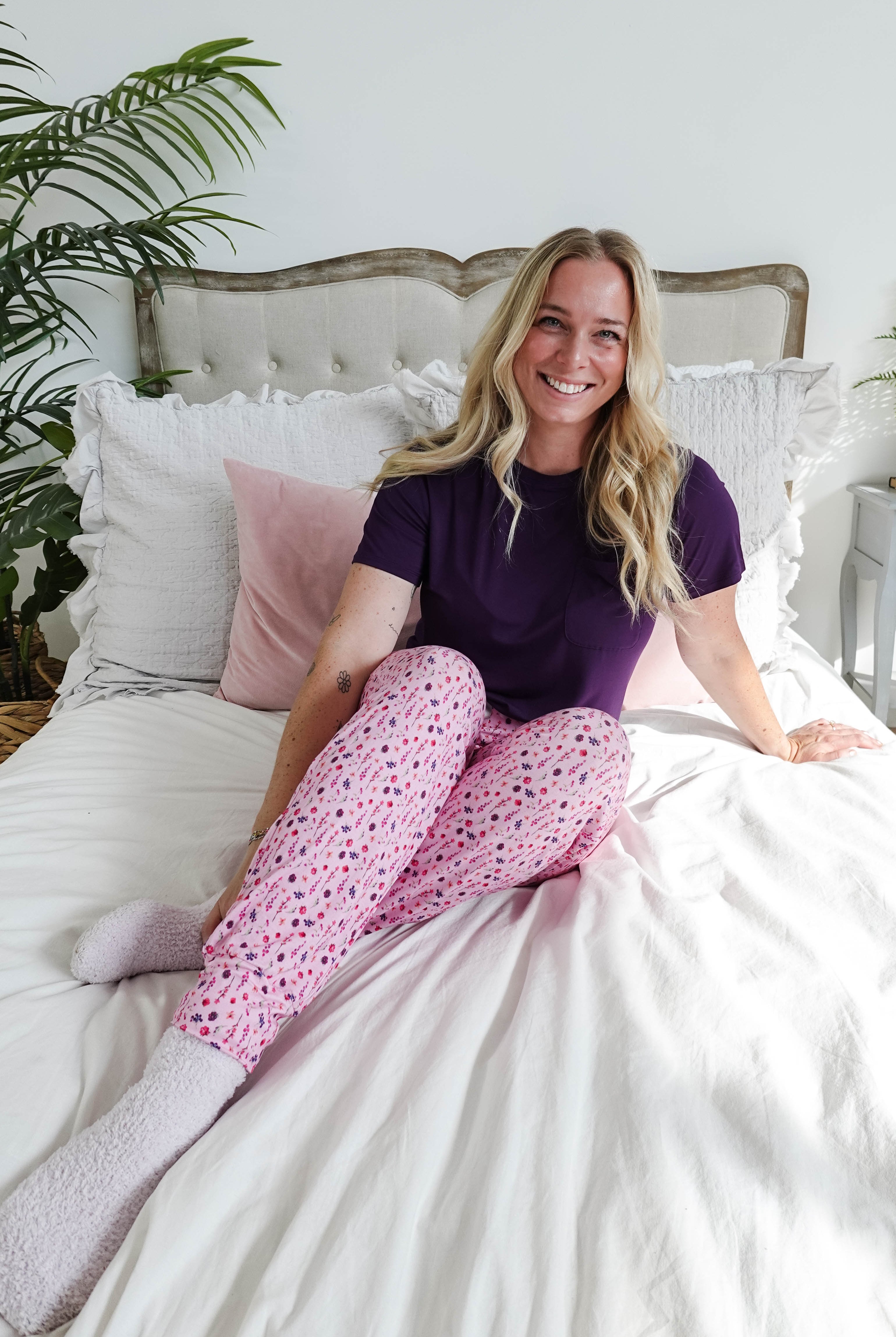 Woman in a purple tee and pink floral jogger pants, showcasing Flora's Garden Print Tee Floral Jogger PJ Set Bamboo from Georgia Rylan.