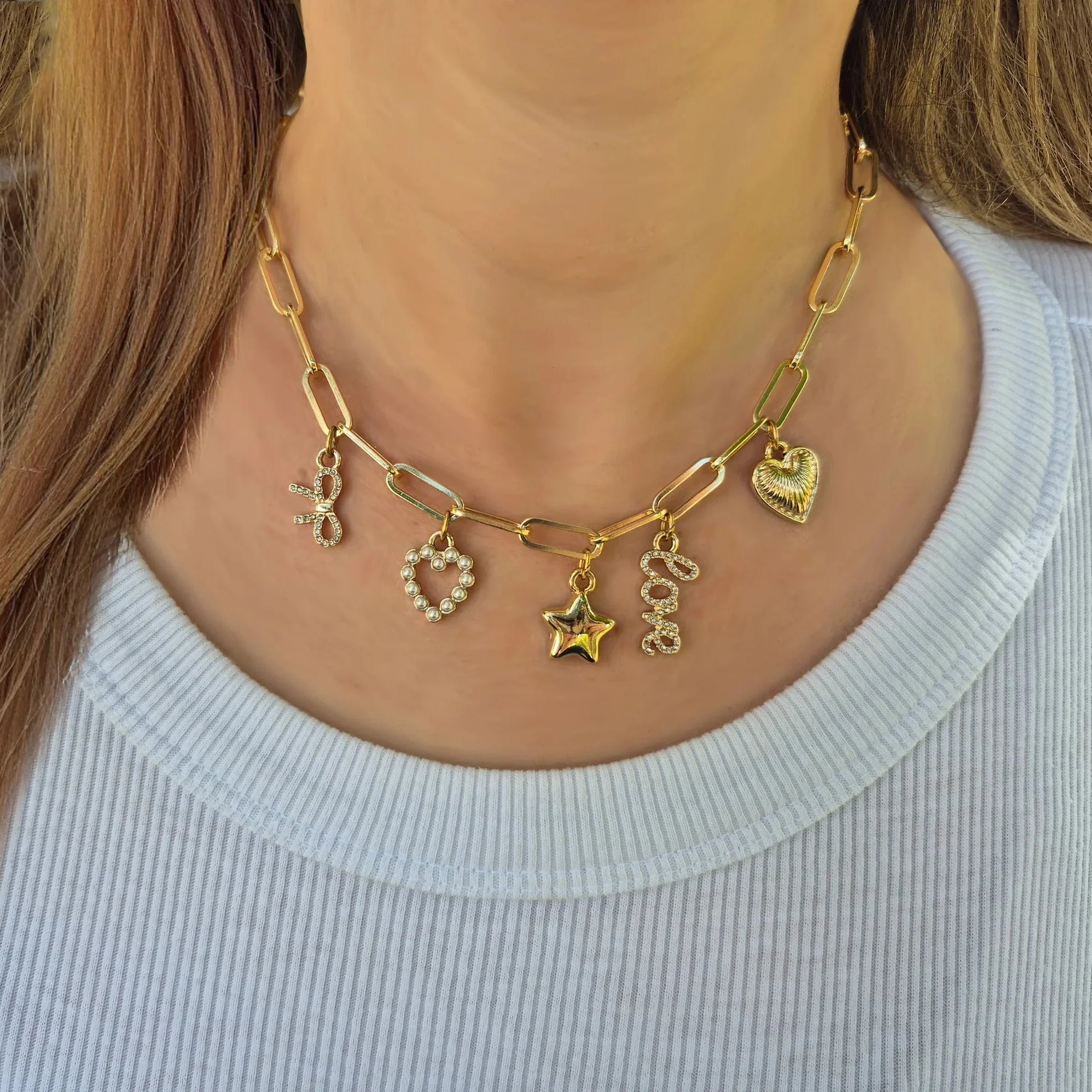Bella Charm Necklace in 14K Gold featuring five charms: heart, star, bow, love script, and pearl heart.