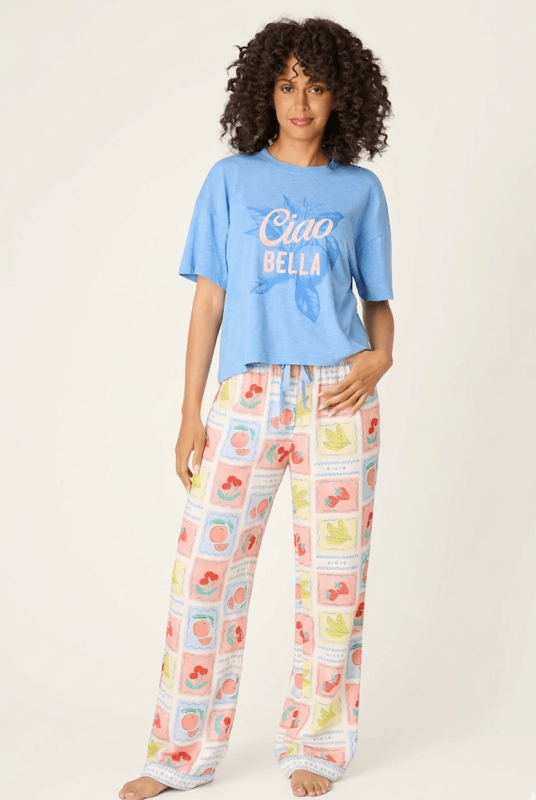 Frutta Fresca Ciao Bella Fruit Print PJ Set by PJ Salvage model wearing a blue top and colorful fruit print pants.