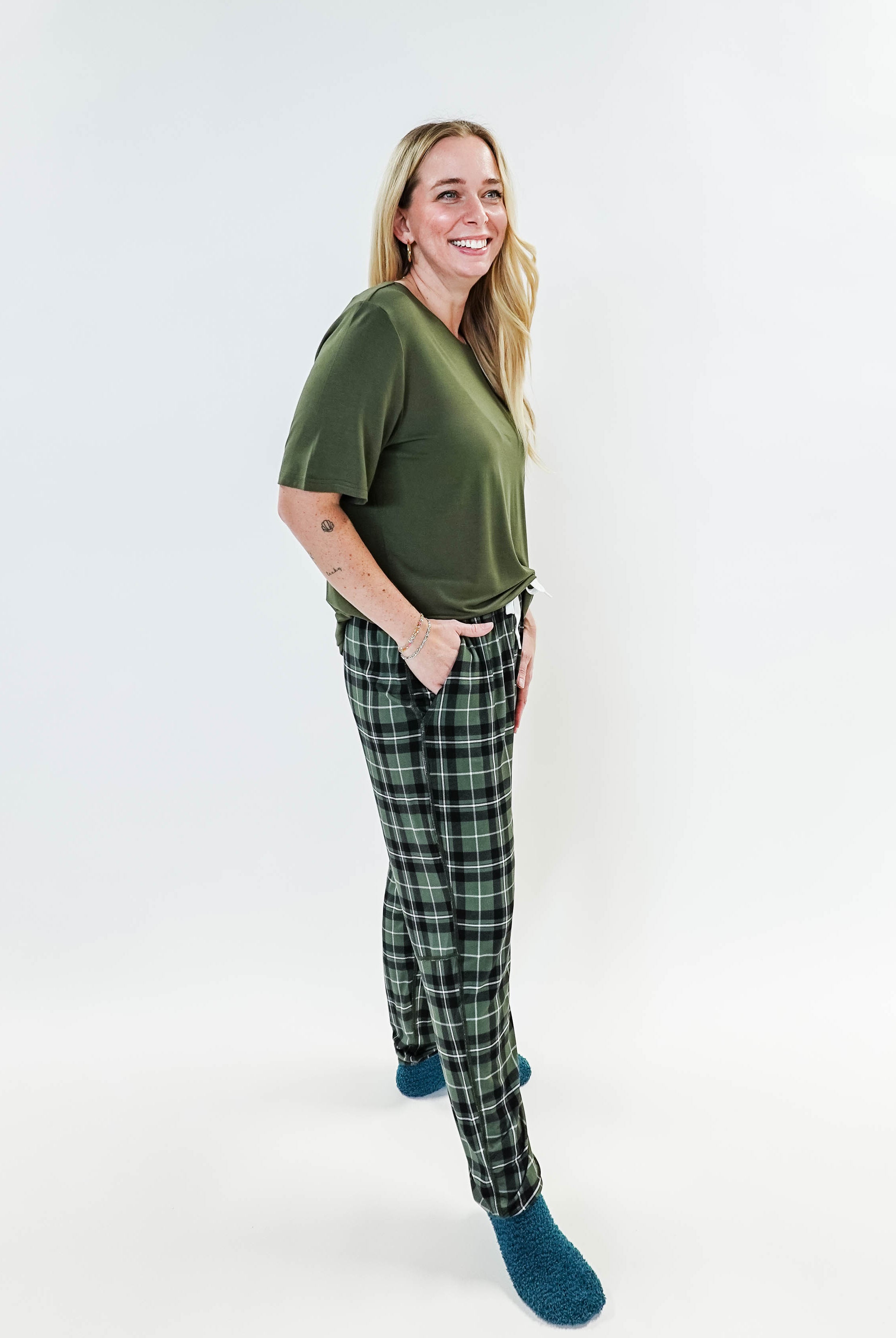 Woman in green top wearing Green Plaid Unisex Bamboo Jogger by Bob's Sleepwear Co. for ultimate comfort.