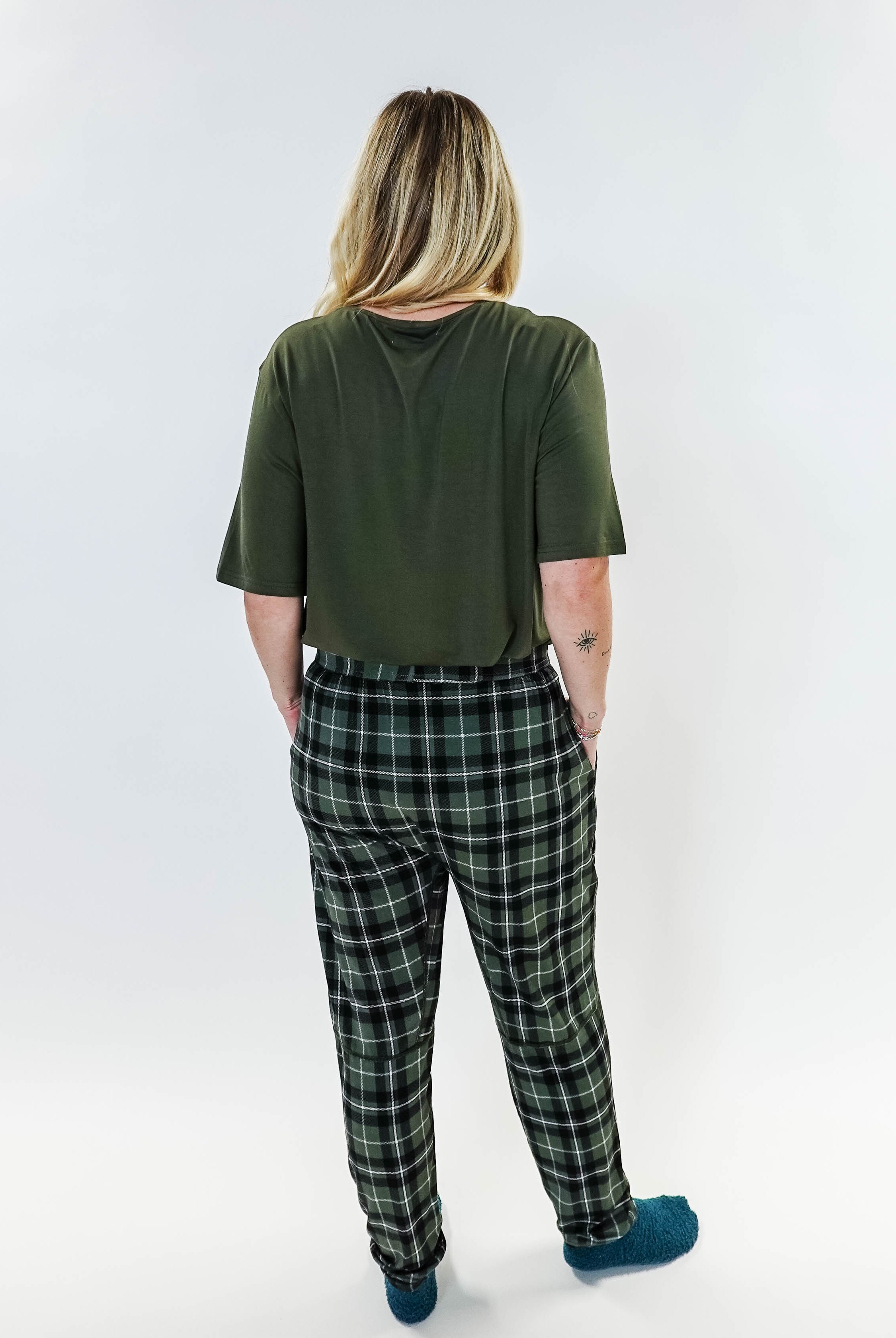 Back view of a person wearing the Green Plaid Unisex Bamboo Jogger from Bob's Sleepwear Co., featuring a comfortable style.