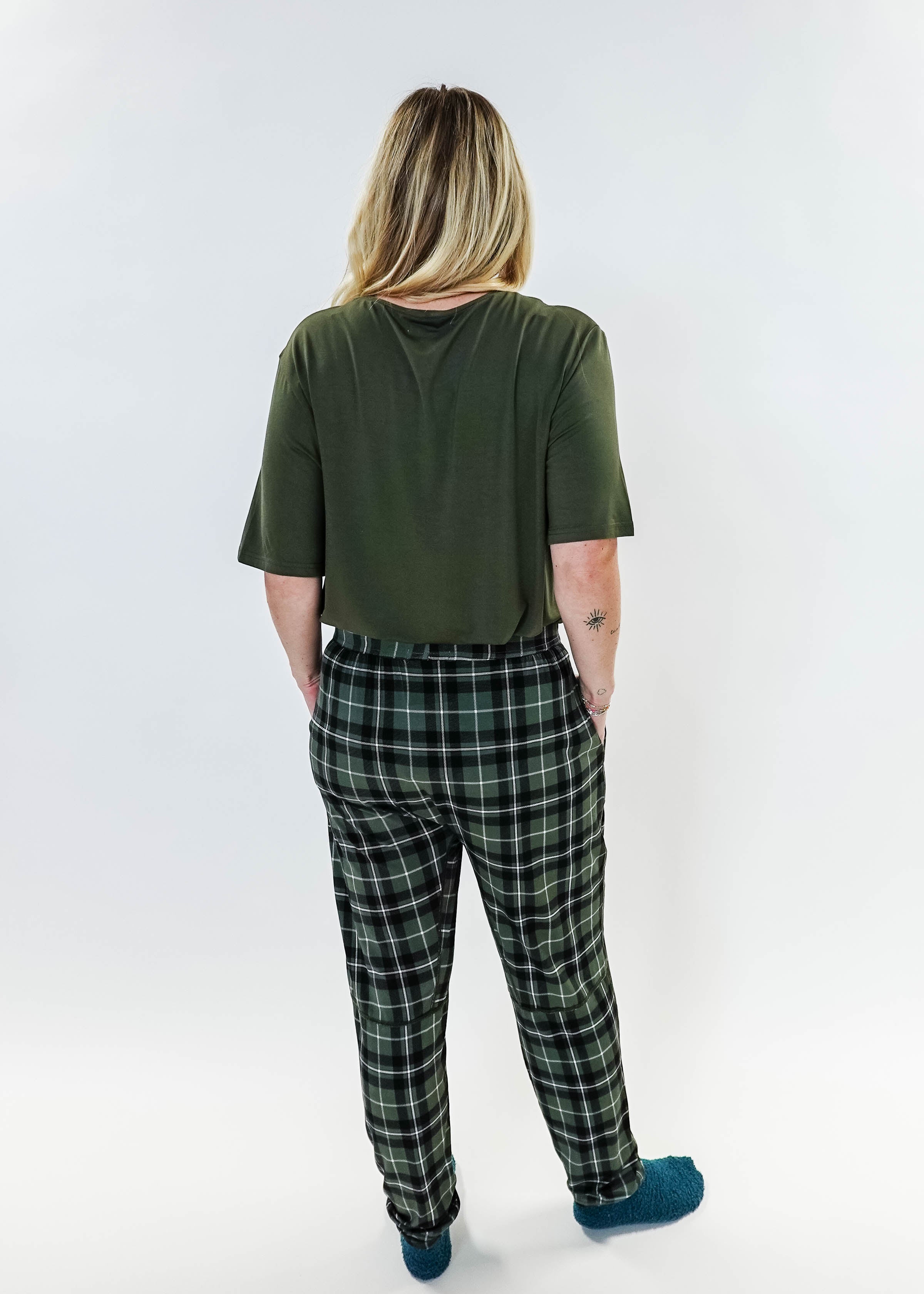 Back view of a person wearing the Green Plaid Unisex Bamboo Jogger from Bob's Sleepwear Co., featuring a comfortable style.