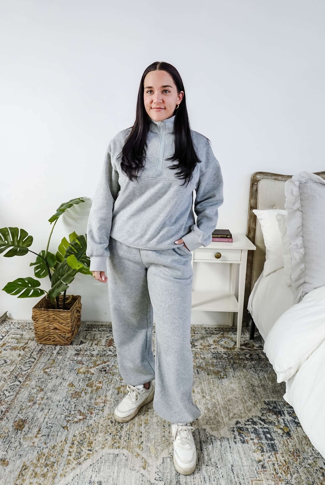 Woman wearing a grey sweatsuit standing in a bedroom with a plant and bed in the background, Scarlett Ellie Half-Zip Sweatsuit Set | Cloud Nine Pajamas