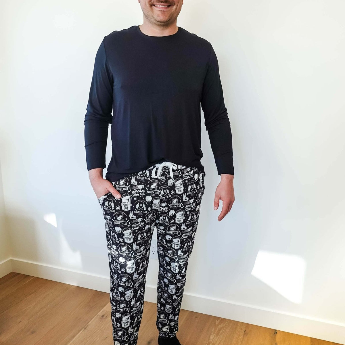 He Scores Hockey Print Unisex Bamboo Jogger showcased on a man wearing a black long sleeve shirt.