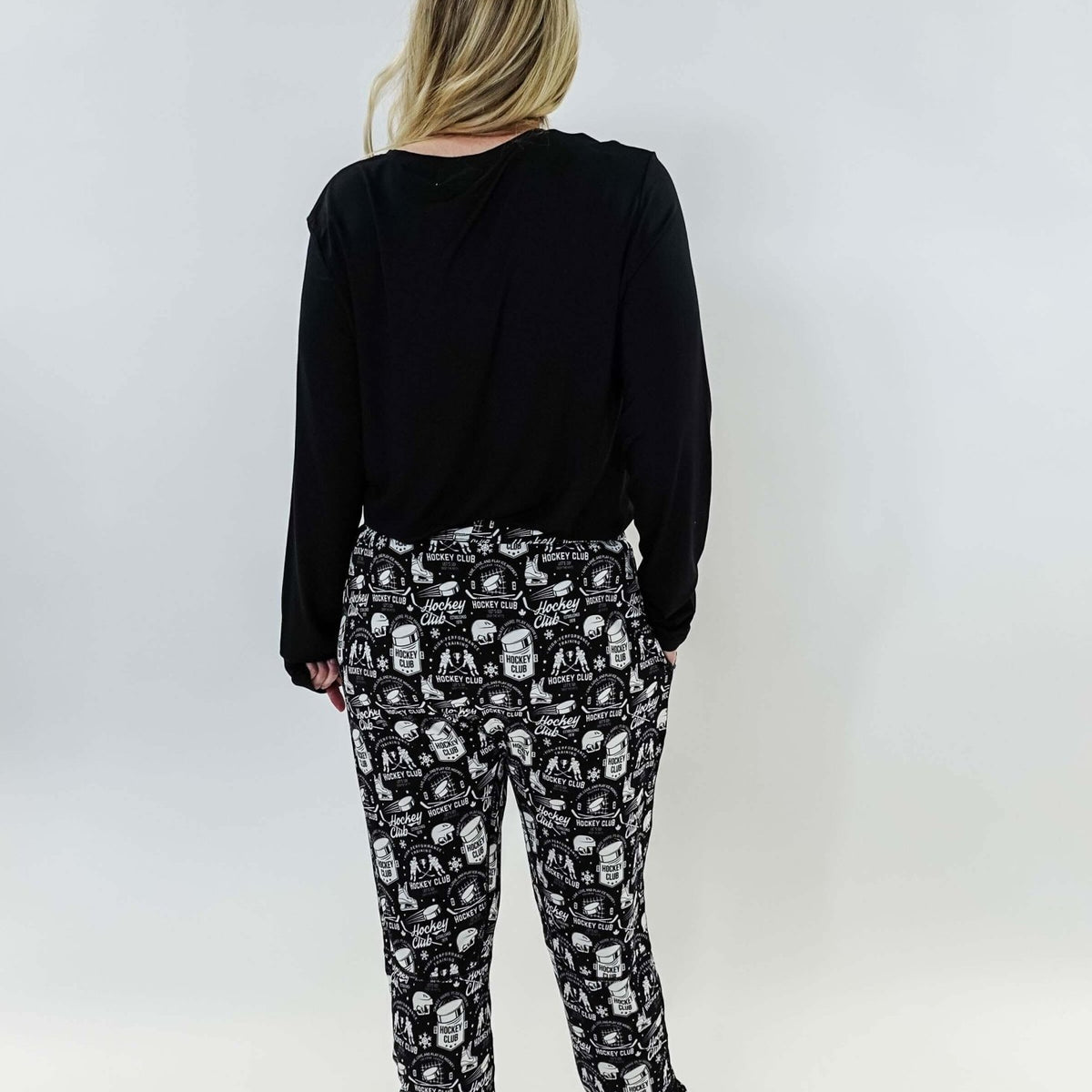 He Scores Hockey Print Unisex Bamboo Jogger worn by a person showing the back view with black top and patterned joggers.
