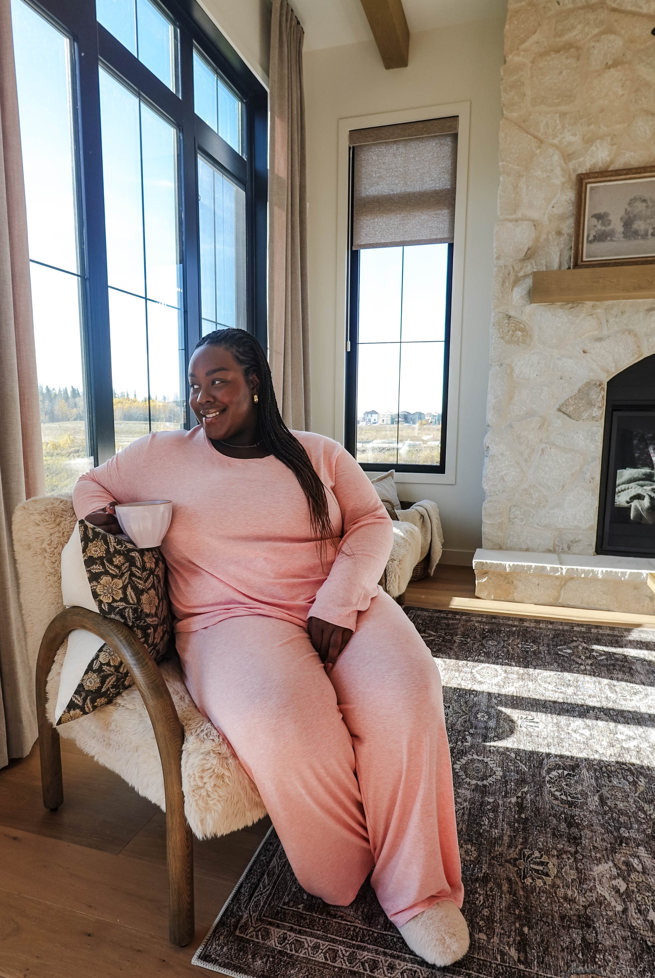 Heather Pink TopStraight Pant Lounge Set worn by a woman sitting in a cozy living room, enjoying a drink.