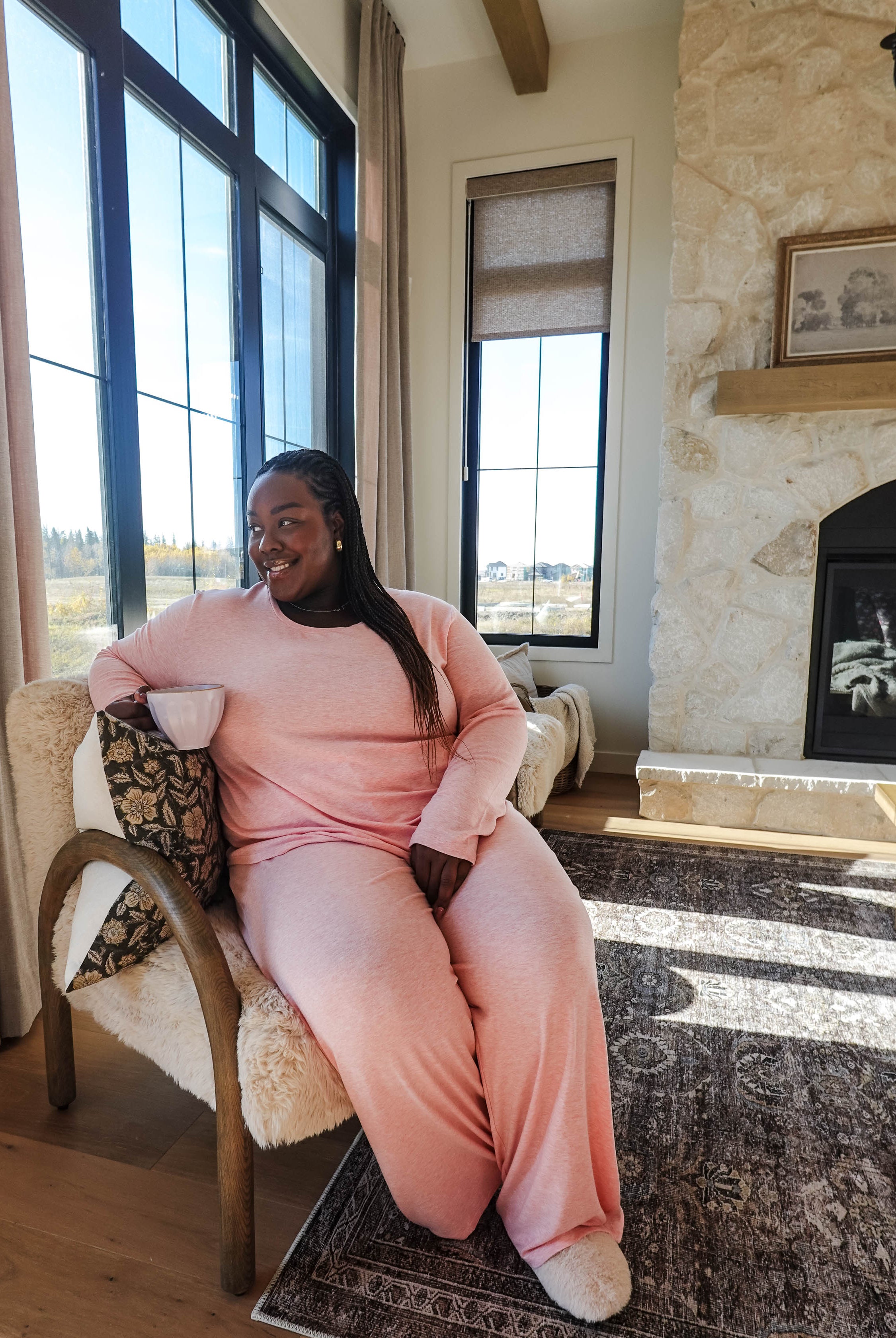 Heather Pink TopStraight Pant Lounge Set worn by a woman sitting in a cozy living room, enjoying a drink.