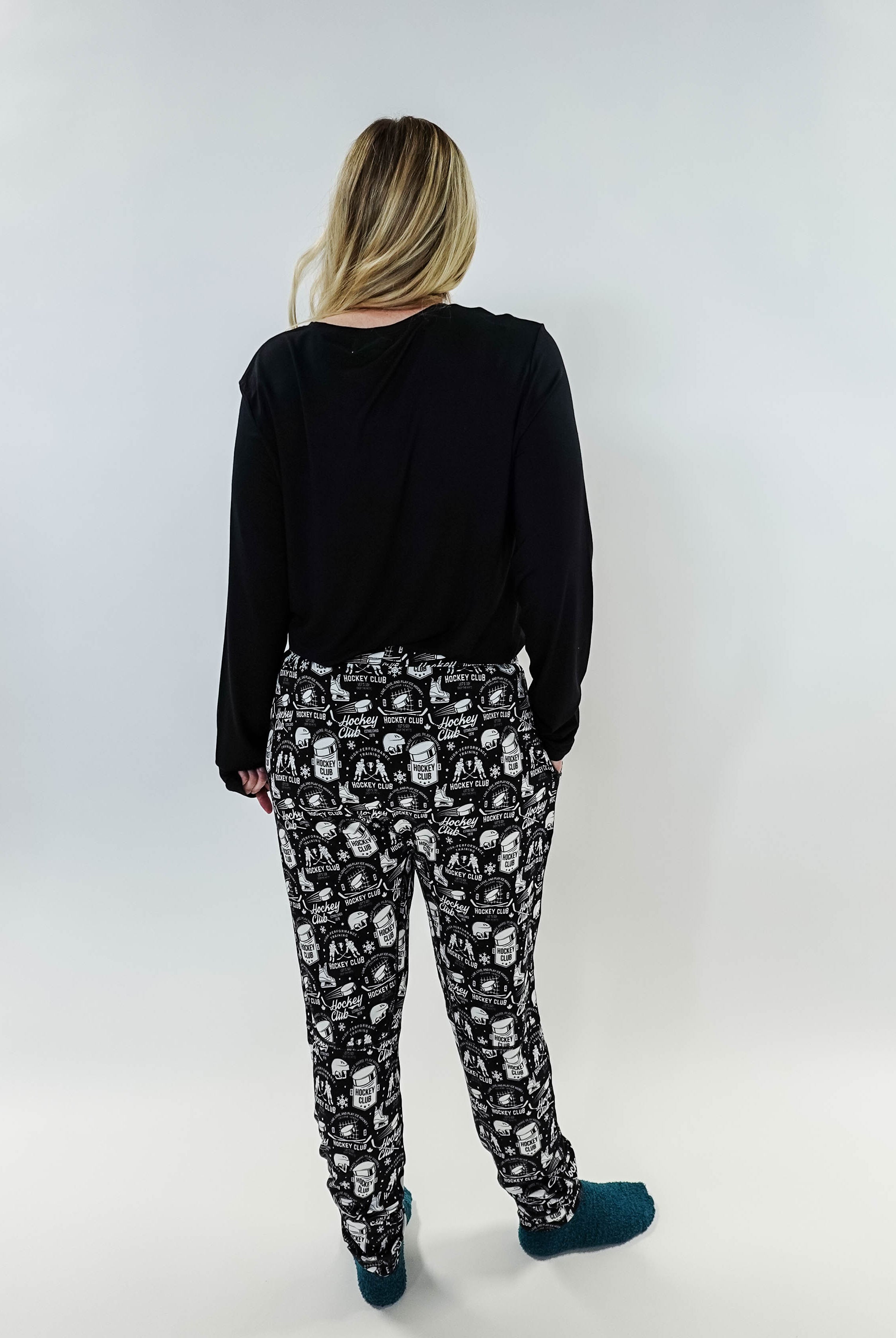 He Scores Hockey Print Unisex Bamboo Jogger worn by a person showing the back view with black top and patterned joggers.