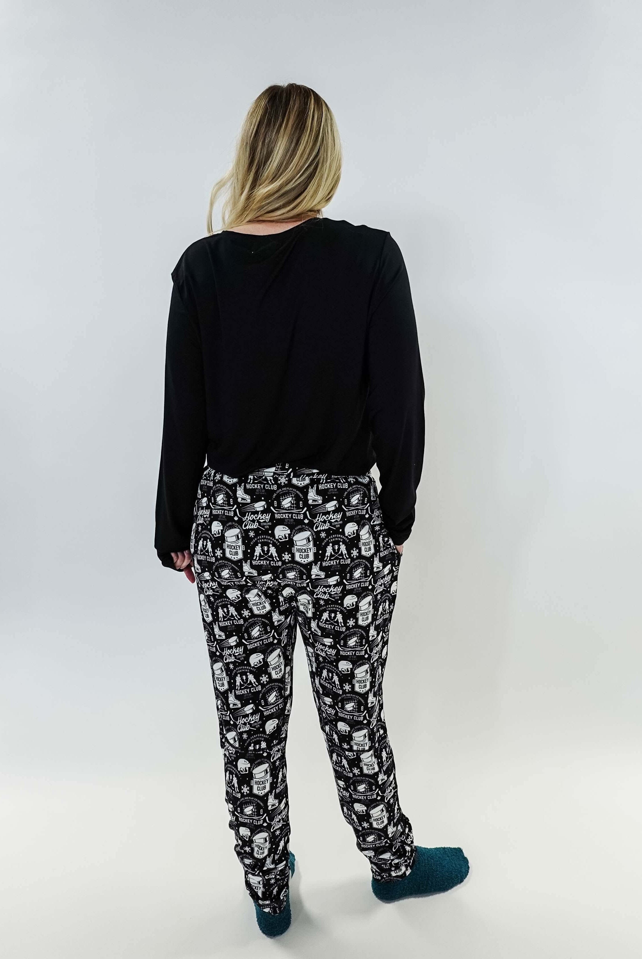 He Scores Hockey Print Unisex Bamboo Jogger worn by a person showing the back view with black top and patterned joggers.