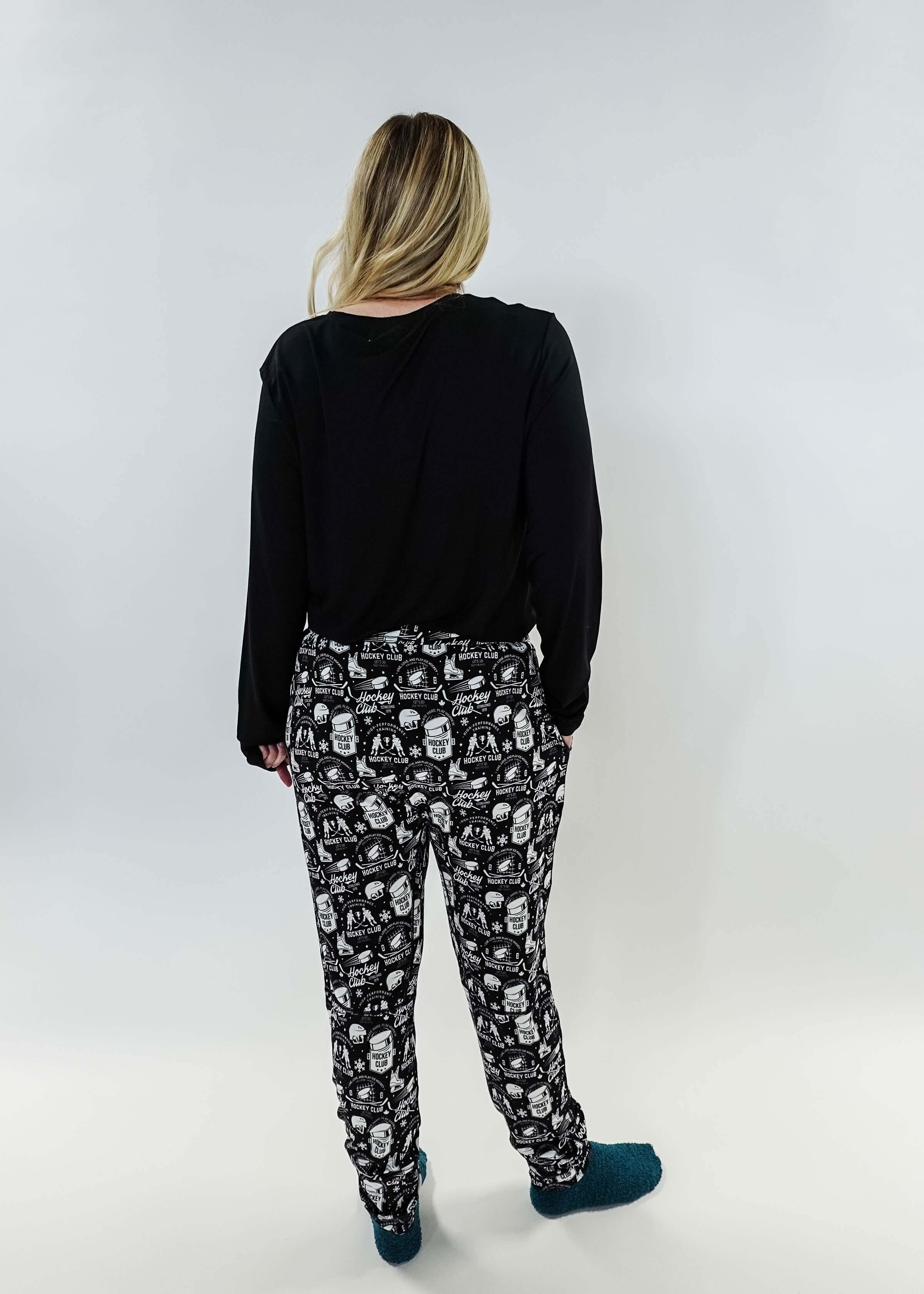 He Scores Hockey Print Unisex Bamboo Jogger worn by a person showing the back view with black top and patterned joggers.