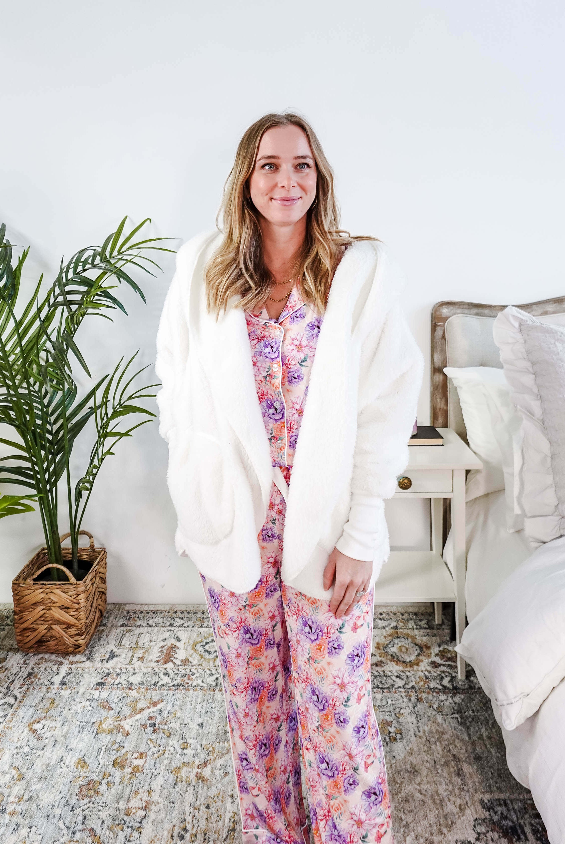 Essential Hooded Fluffy Cozy Cardigan with Pockets worn by a woman with floral pajamas in a cozy bedroom setting.