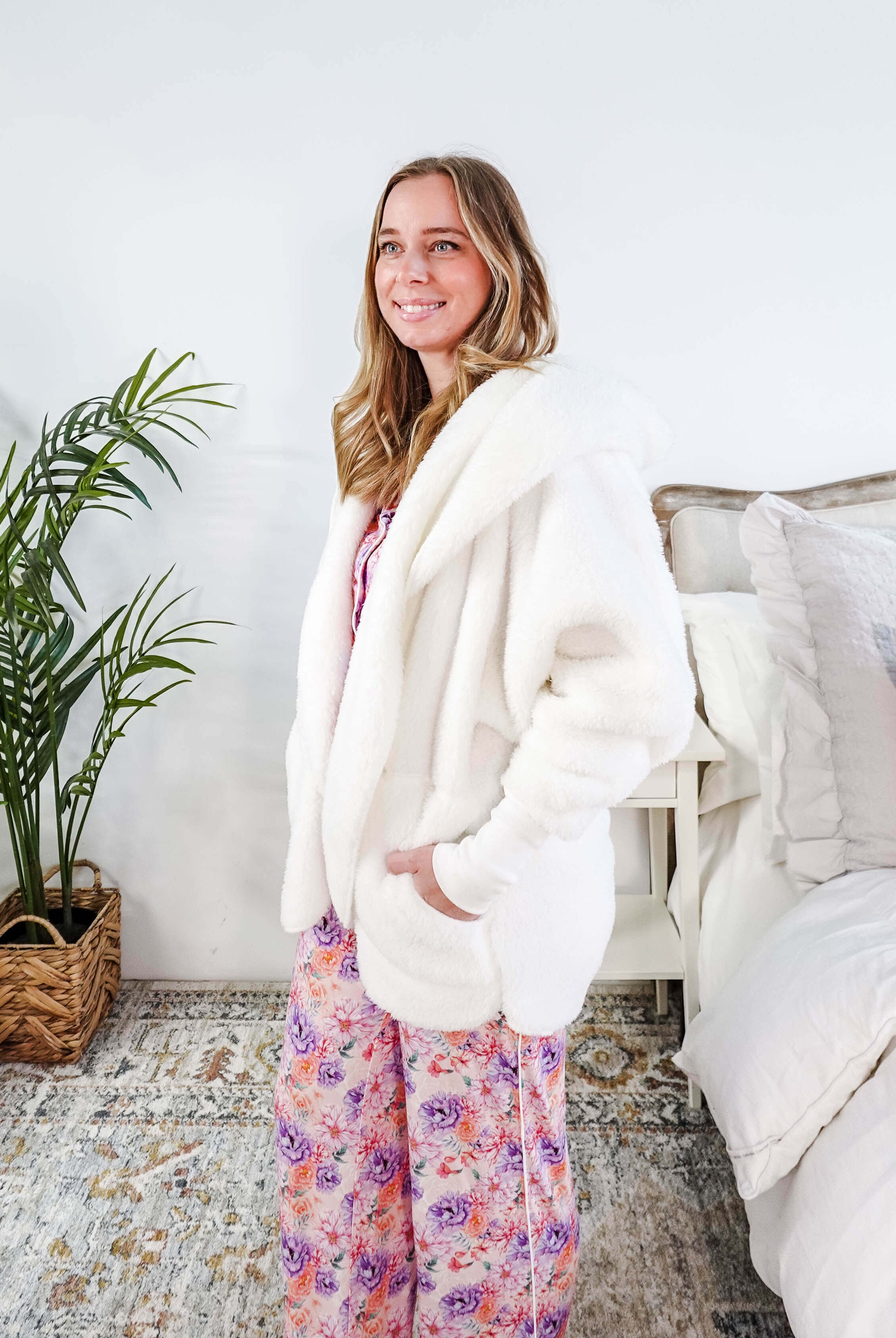 Essential Hooded Fluffy Cozy Cardigan with Pockets worn by a woman with floral pajamas in a cozy bedroom setting.