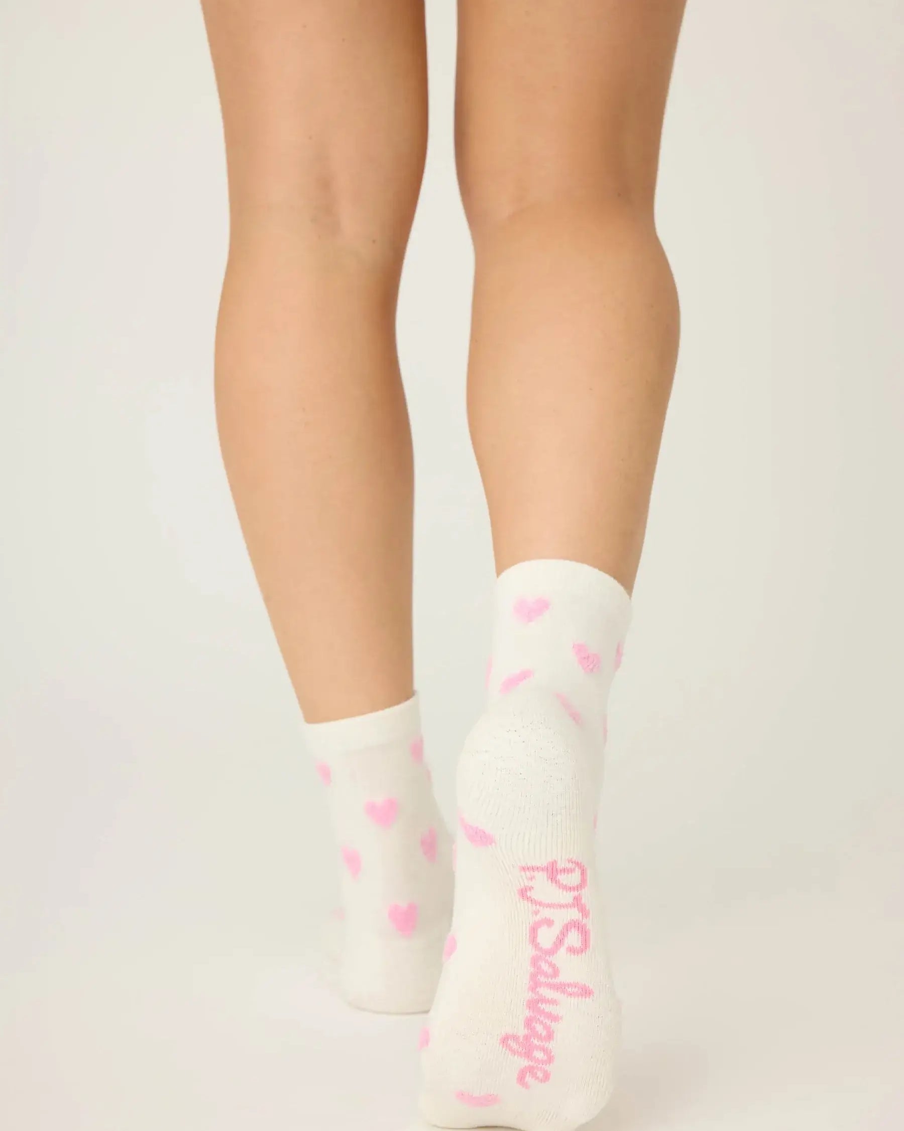 Pair of PJ Salvage "Love You A Latte" Fuzzy Crew Socks in ivory with an all-over pink heart print. Showing the mid-height crew cut and plush texture.