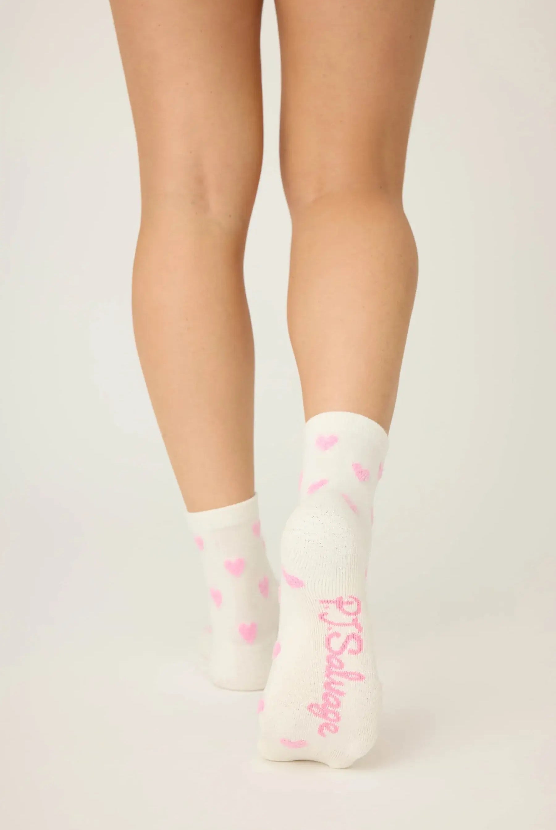 Pair of PJ Salvage "Love You A Latte" Fuzzy Crew Socks in ivory with an all-over pink heart print. Showing the mid-height crew cut and plush texture.
