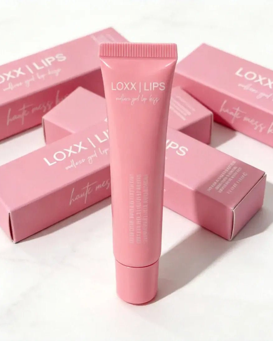 LOXX LIPS Peptide Lip Gloss Haute Mess Kiss Pink Tint packaging and product tube on display.