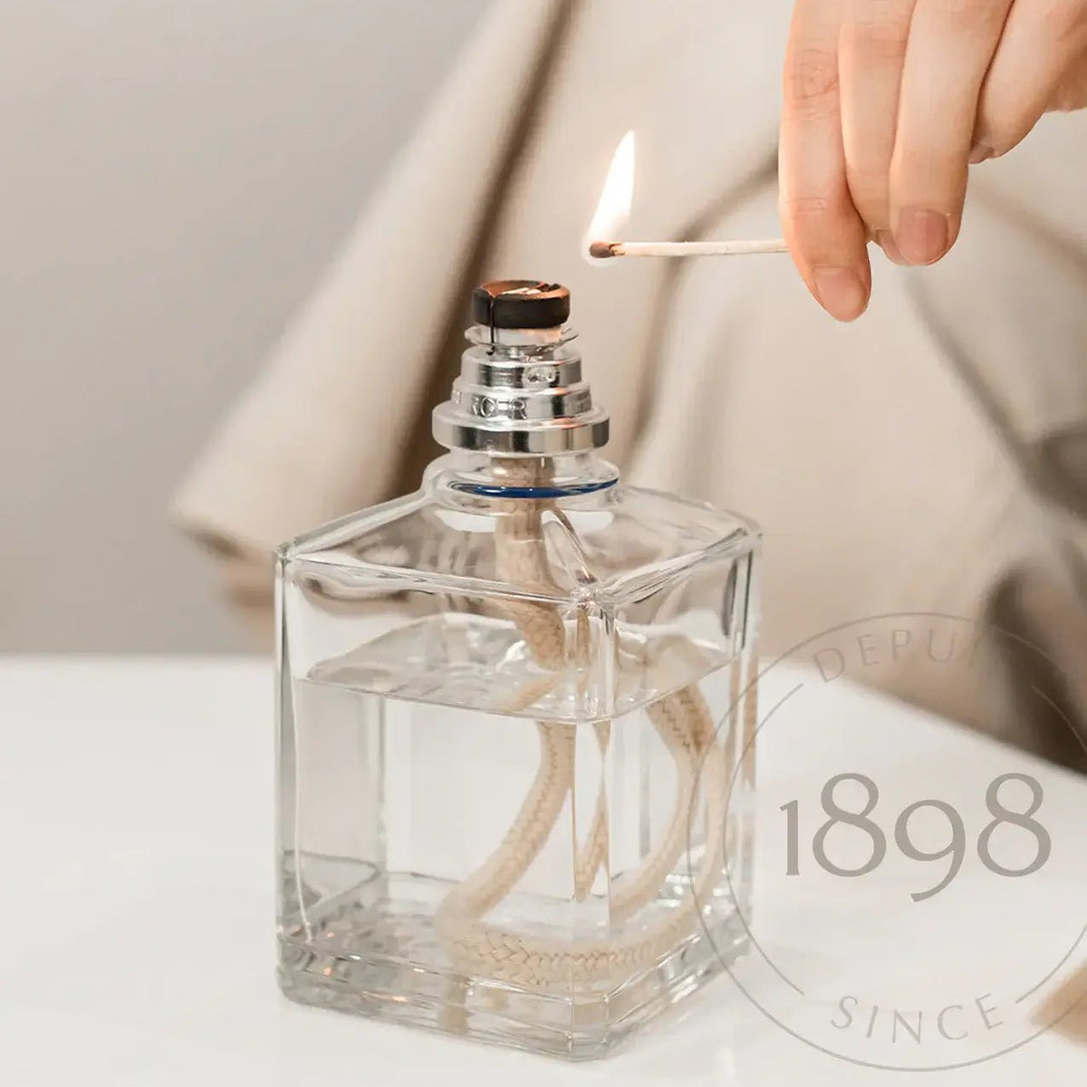 Maison Berger Square Glass Lamp view with match being lit — Cloud Nine Pajamas Edmonton