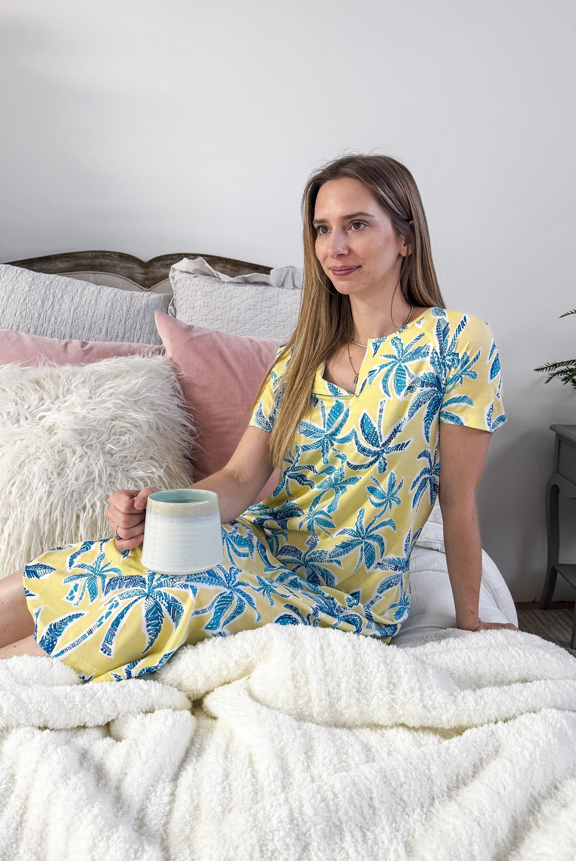 Model (5'7") wearing the Cool Girl "Mai Tai" Tropical Print Nightgown in a full-length cut with short sleeves and a V-neck, showcasing the yellow and blue palm print.