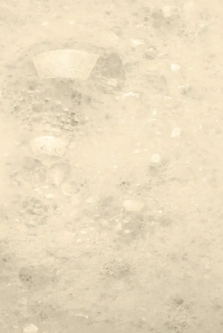 Oatmeal & Honey Bubbly Bath Salts dissolving to create fluffy bubbles in a warm bath.