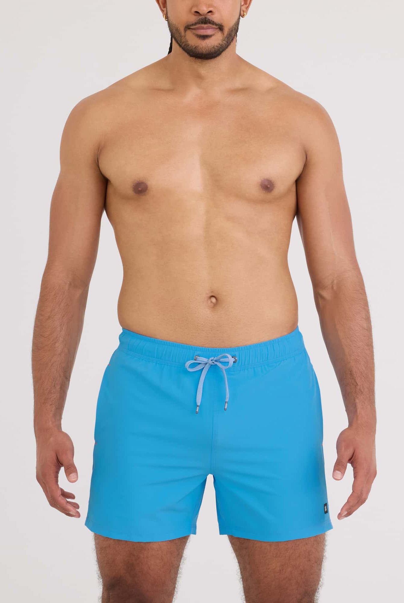 Model wearing Oh Buoy 2N1 Volley Swim Short 5" in vibrant blue color, showcasing a relaxed summer look.