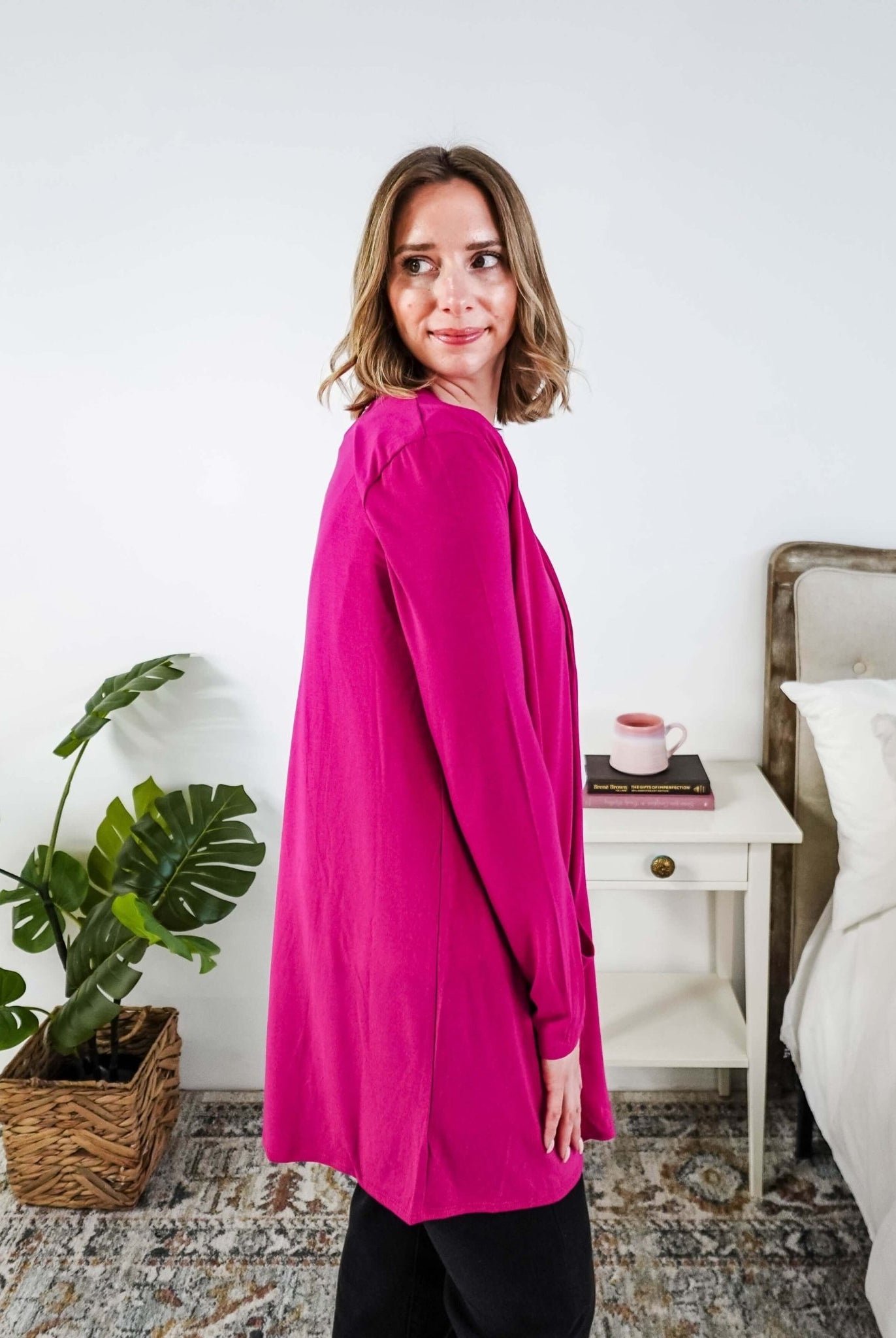 Woman in a bright pink cardigan standing in a bedroom. Scarlett Ellie Summer Open Lightweight Cardigan | Cloud Nine Pajamas