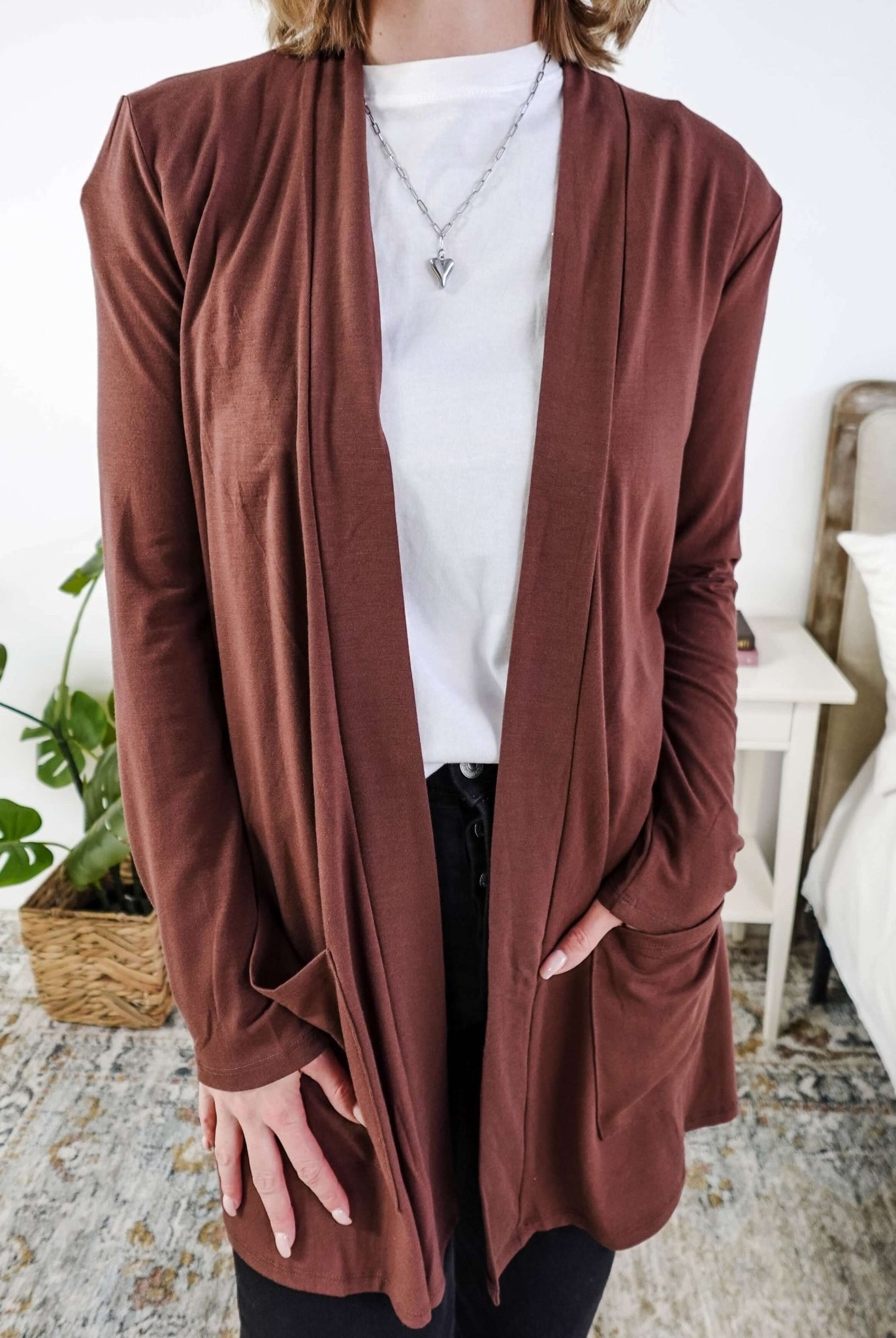Person wearing a brown cardigan over a white shirt in a casual setting. Scarlett Ellie Summer Open Lightweight Cardigan | Cloud Nine Pajamas