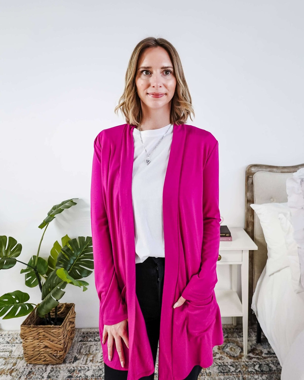 Woman wearing a bright pink cardigan in a bedroom setting Scarlett Ellie Summer Open Lightweight Cardigan | Cloud Nine Pajamas