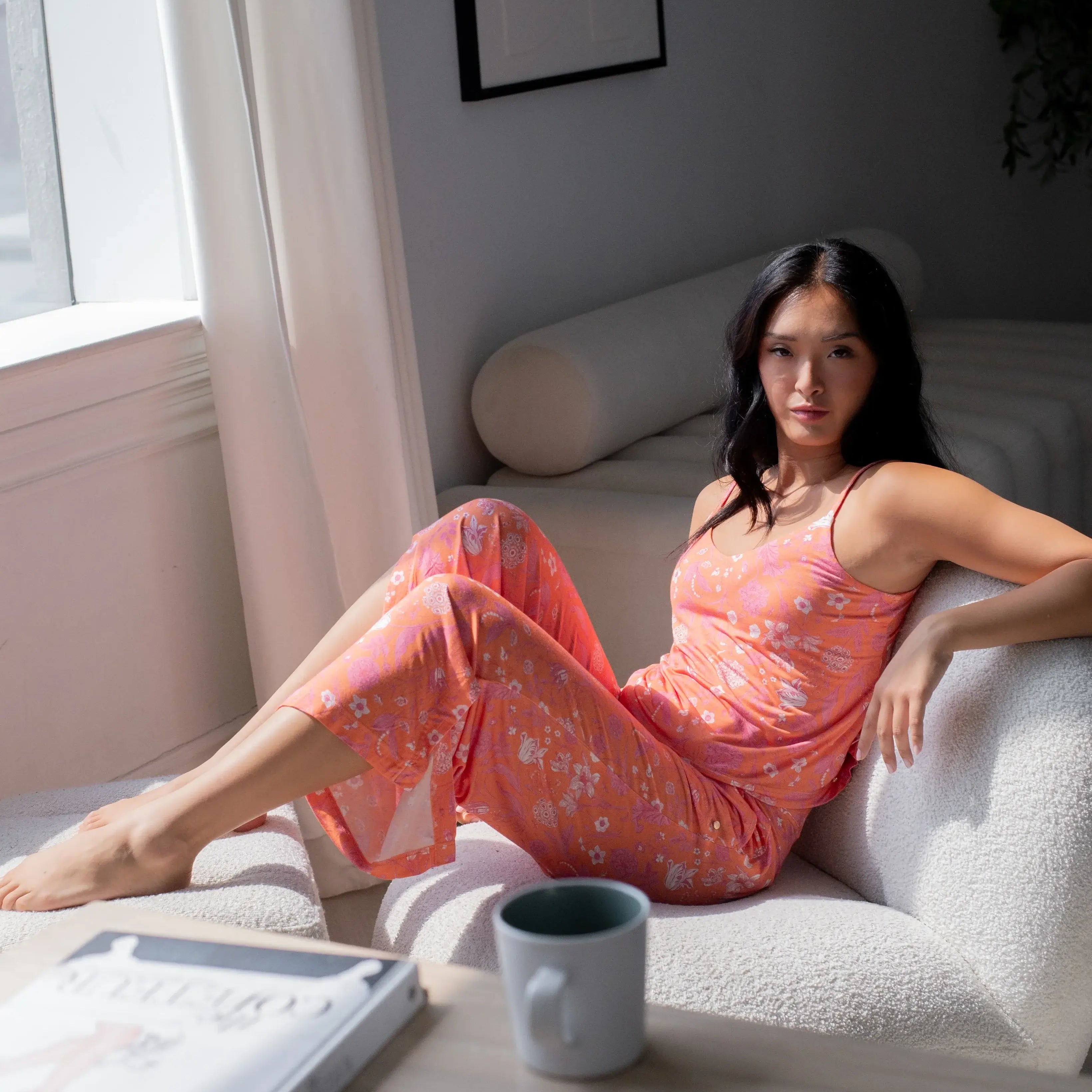 Woman lounging in Cami & High Waist Capri PJ Set, enjoying comfort in a bright, stylish sleepwear ensemble.