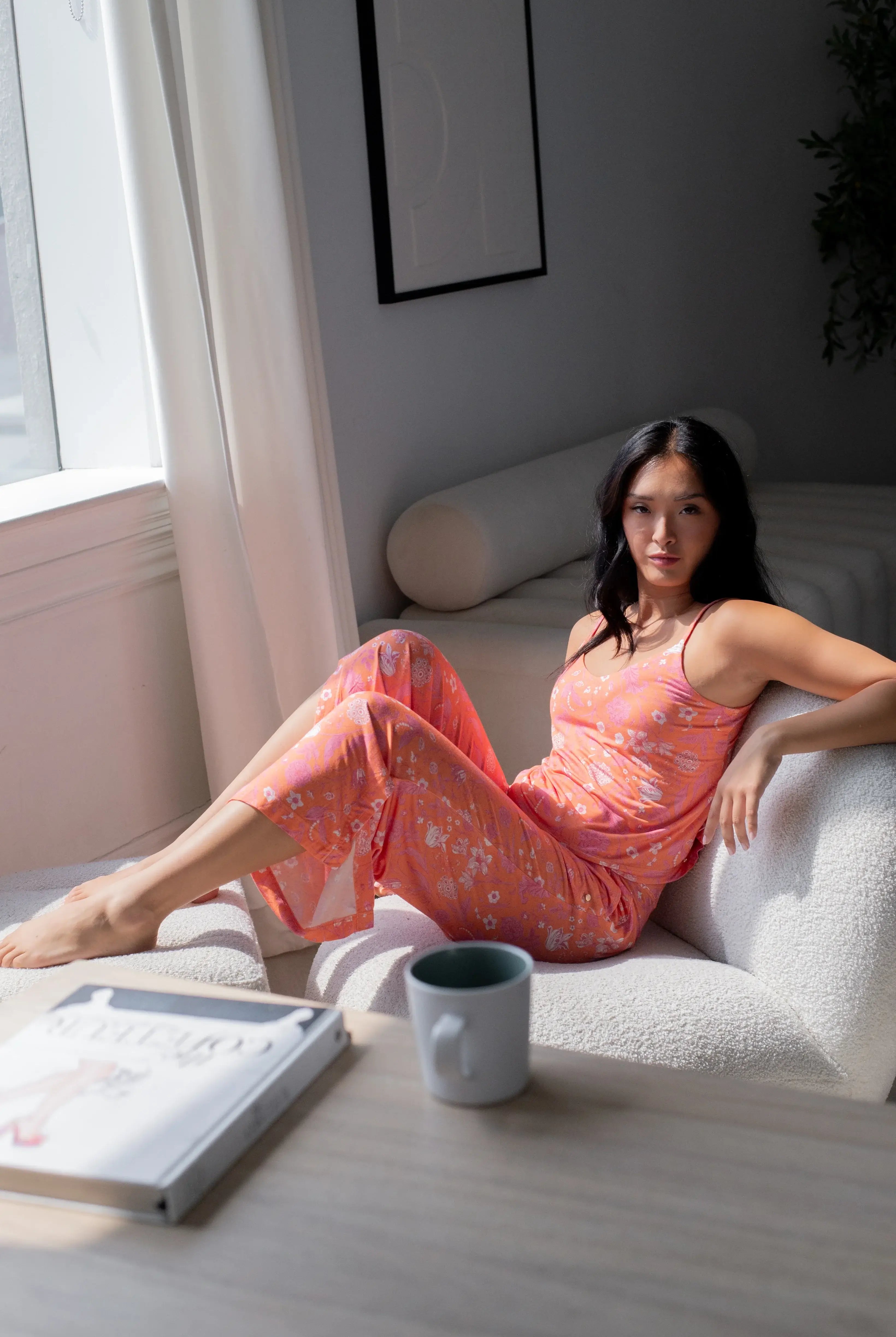 Woman lounging in Cami & High Waist Capri PJ Set, enjoying comfort in a bright, stylish sleepwear ensemble.