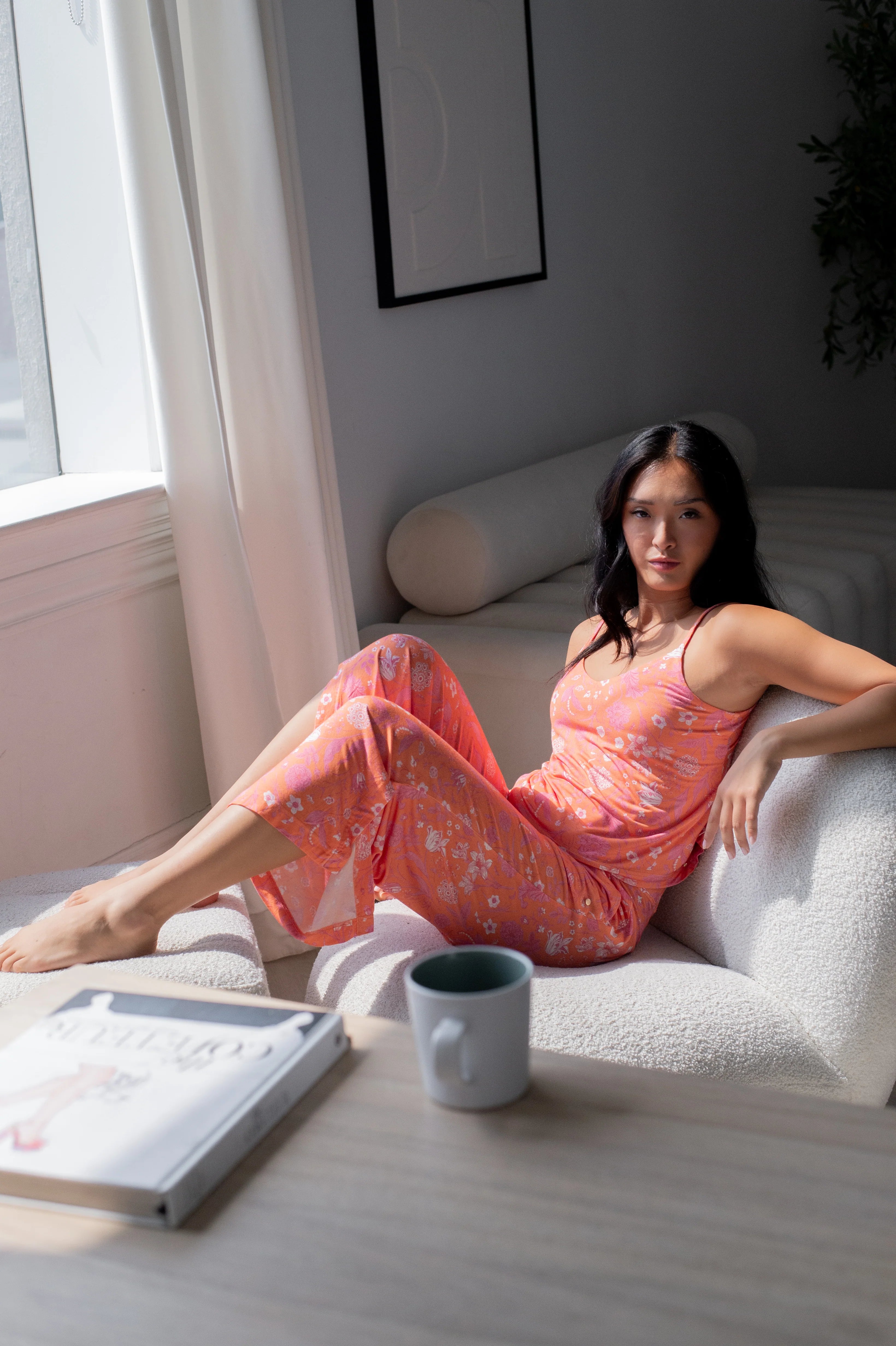 Woman lounging in Cami & High Waist Capri PJ Set, enjoying comfort in a bright, stylish sleepwear ensemble.