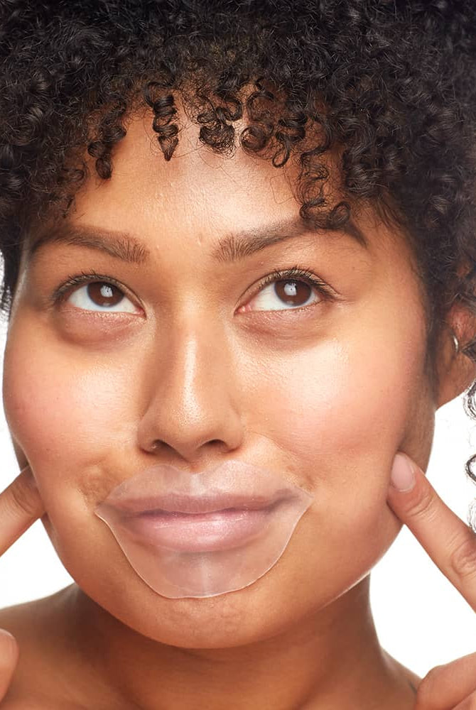 Woman applying Patchology FlashPatch Hydrating Lip Gels for a plump, moisturized pout.