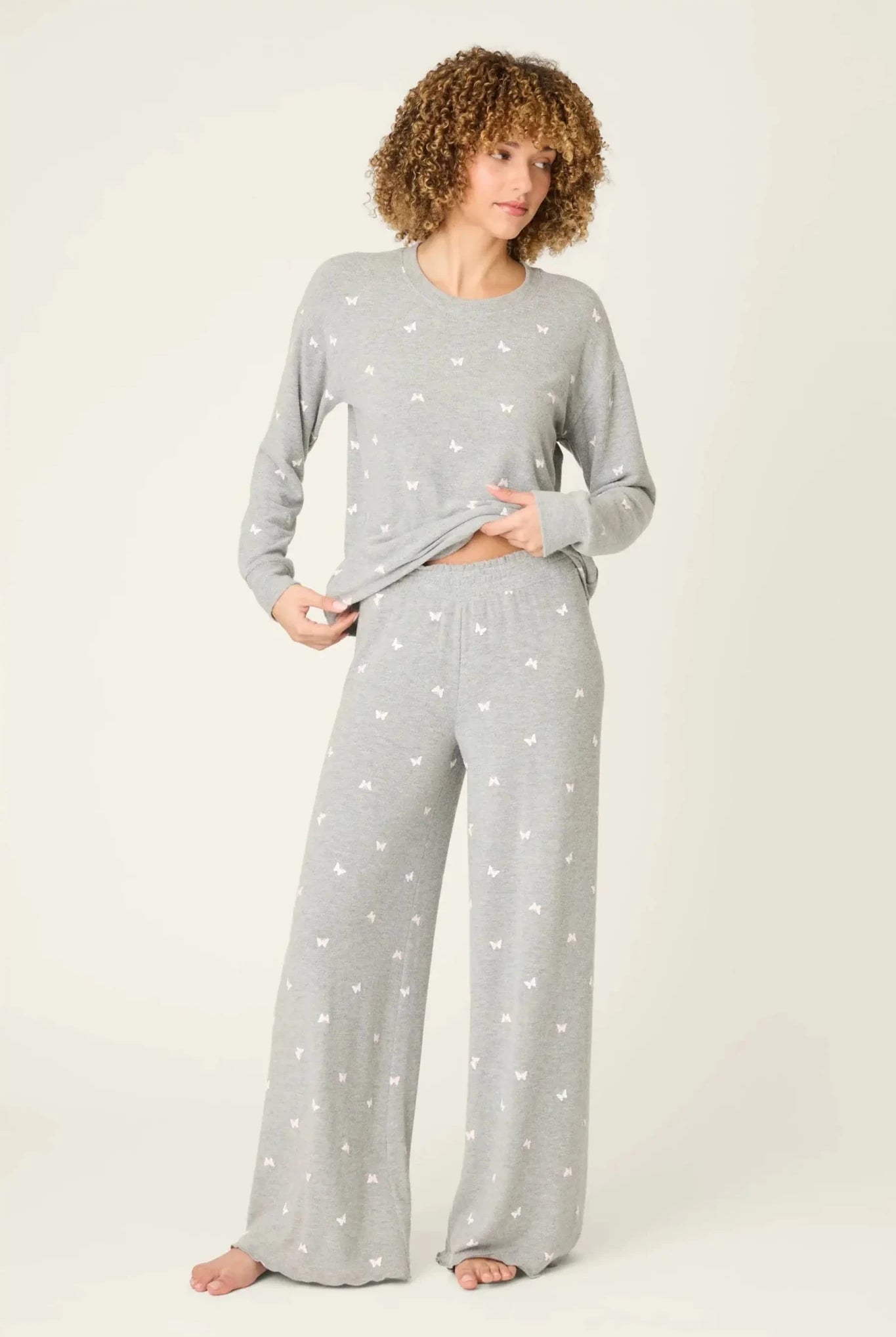 Model wearing PJ Salvage Peachy Butterfly Kisses Lounge Set featuring a heathered grey top and wide-leg pants.
