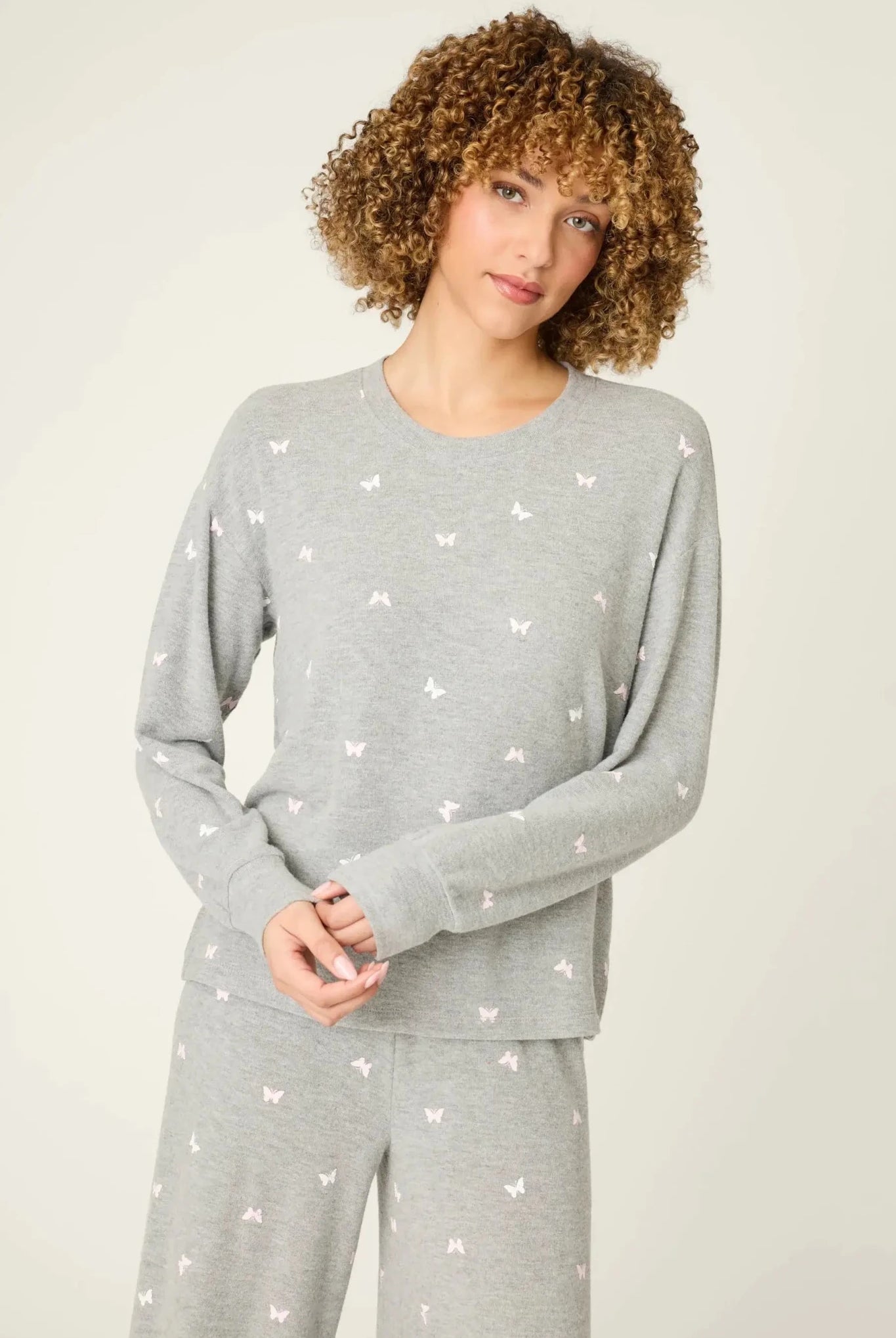Model wearing PJ Salvage Peachy Butterfly Kisses Lounge Set featuring a butterfly print on a grey fabric.