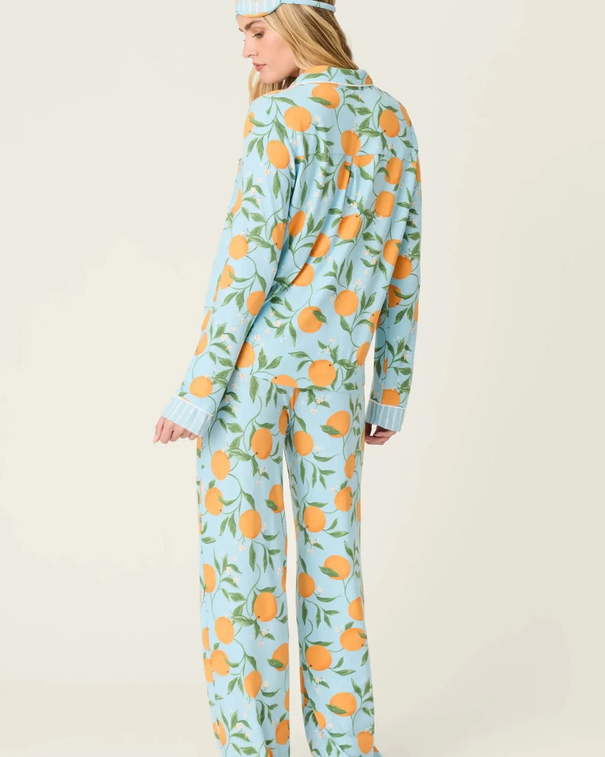 Model wearing PJ Salvage Citrus Dreams 3-Piece PJ Set featuring orange design with matching eye mask. Back View