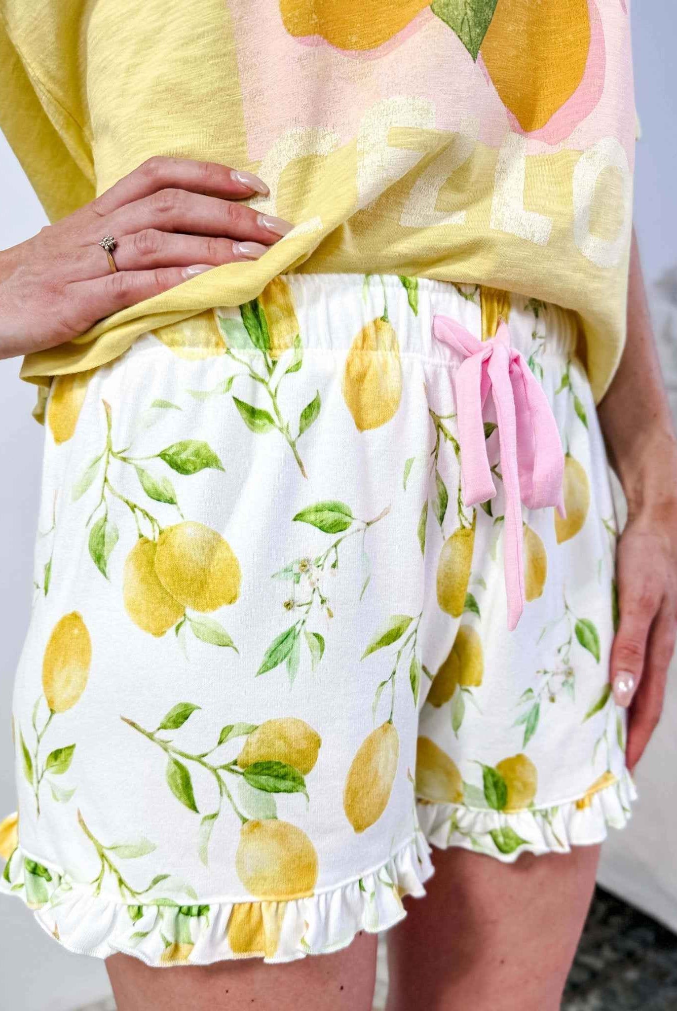 PJ SALVAGE — La Dolce Spritz Limoncello Graphic Tee & Lemon Zest Short Set shown on model in bedroom setting, close up shot of short print and details