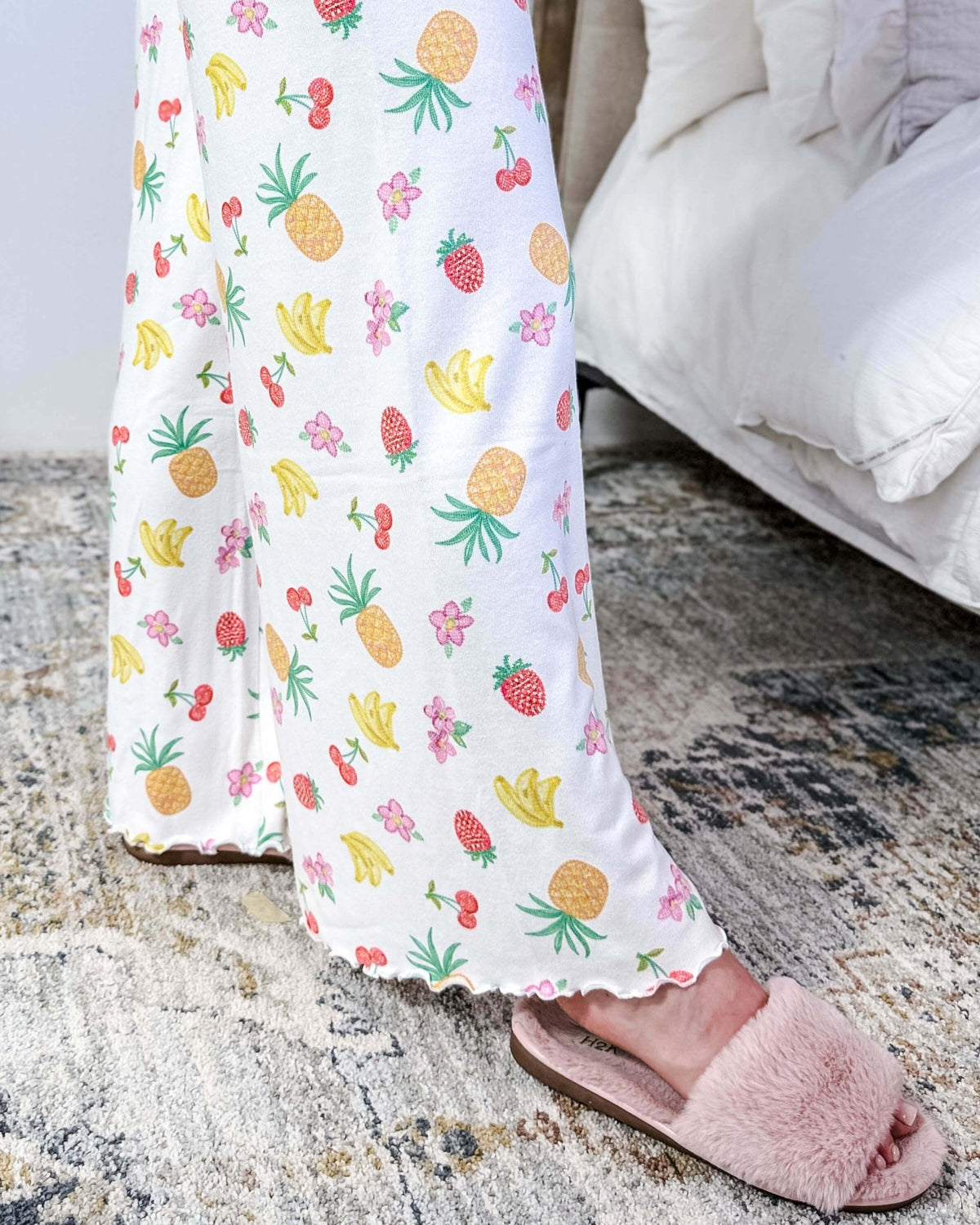 PJ SALVAGE — Viva la Vida Fruit Fiesta Long Sleeve & Pant Set worn on model in a bedroom setting, showing lettuce scalloped detail of the hem of the straight leg pant