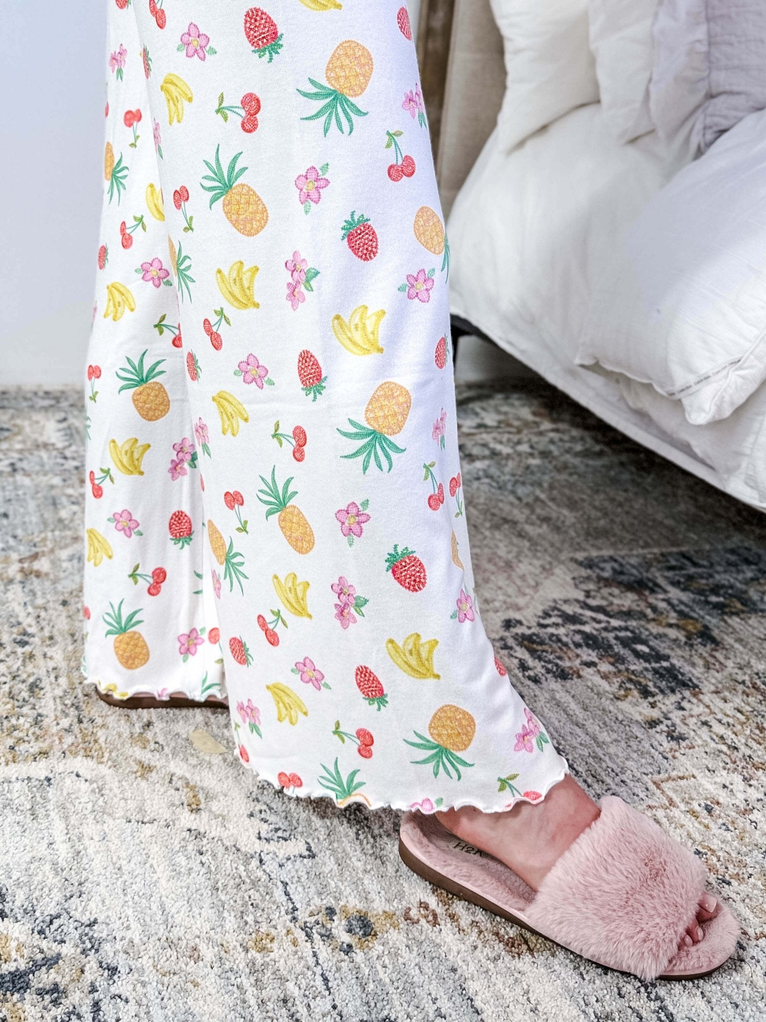 PJ SALVAGE — Viva la Vida Fruit Fiesta Long Sleeve & Pant Set worn on model in a bedroom setting, showing lettuce scalloped detail of the hem of the straight leg pant