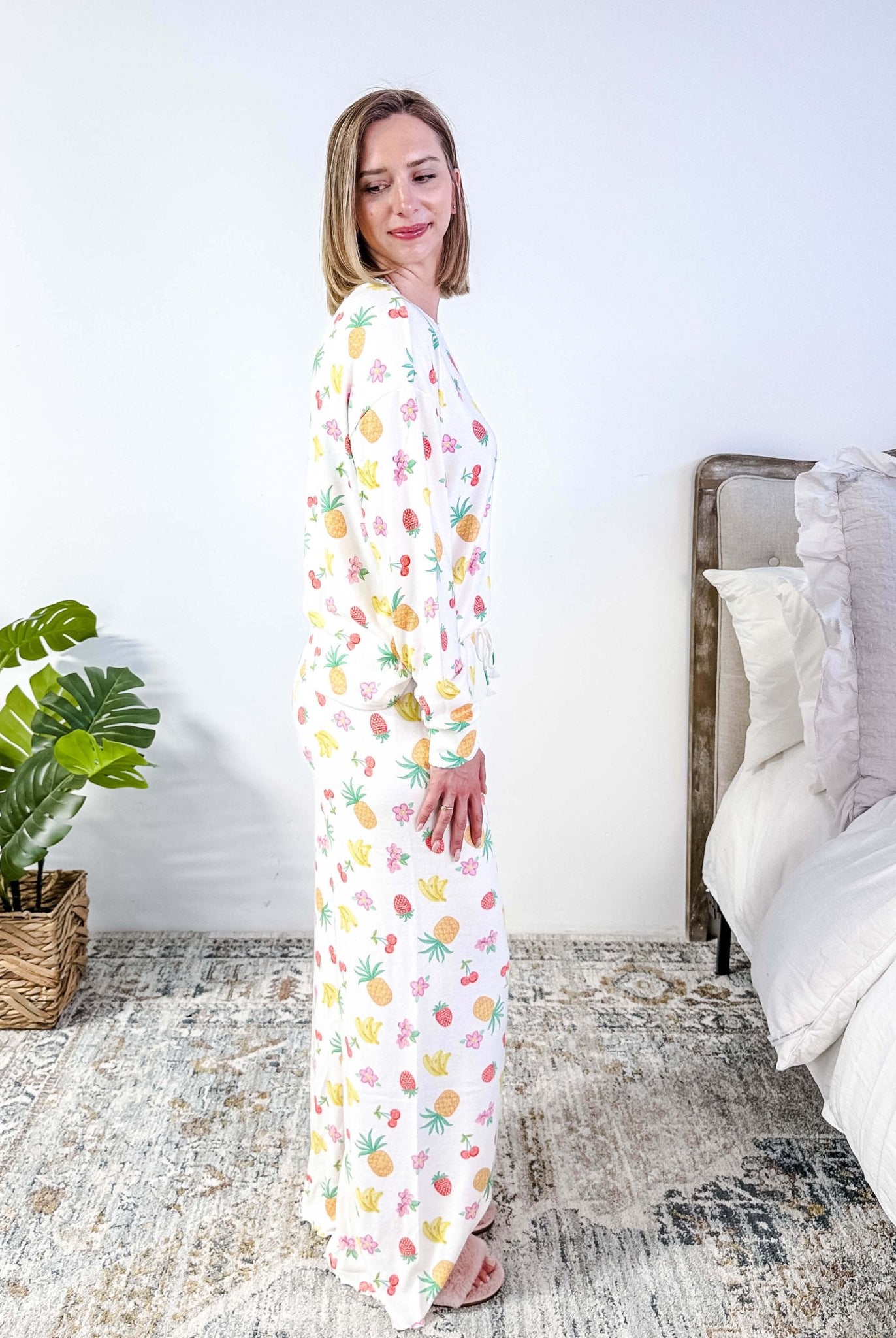 PJ SALVAGE — Viva la Vida Fruit Fiesta Long Sleeve & Pant Set worn on model in a bedroom setting, showing full length of the fruit print pj set from a side profile